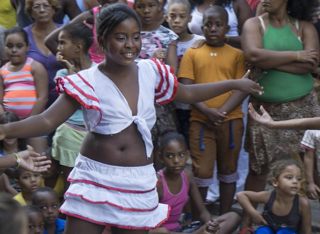 Niña bailando salsa con traje blanco