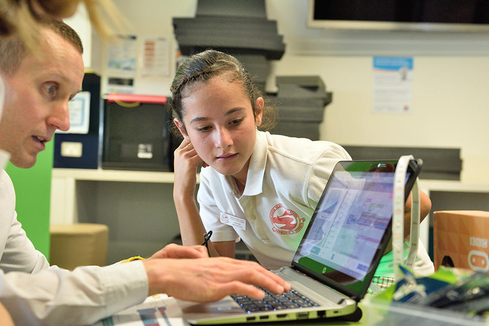 Estudiante y profesor frente a computador