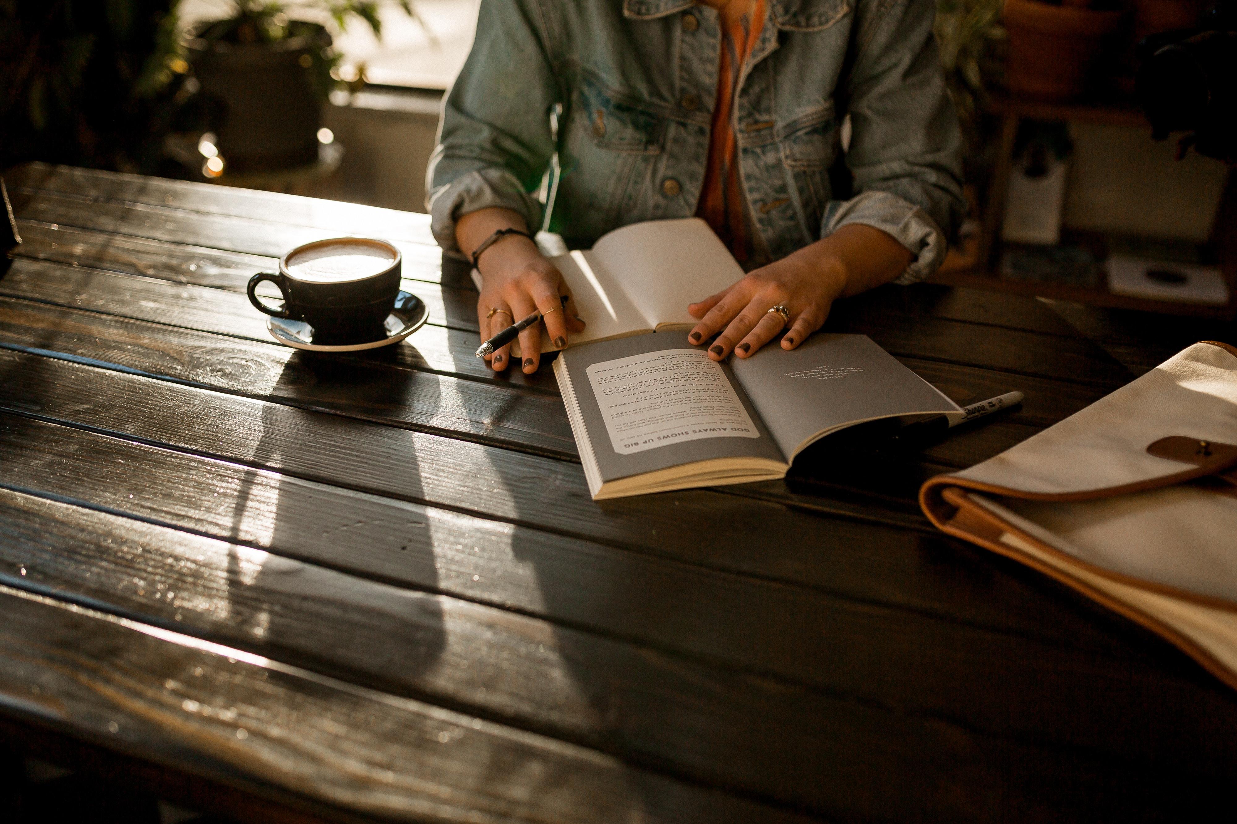 Personas abriendo libro sobre la mesa