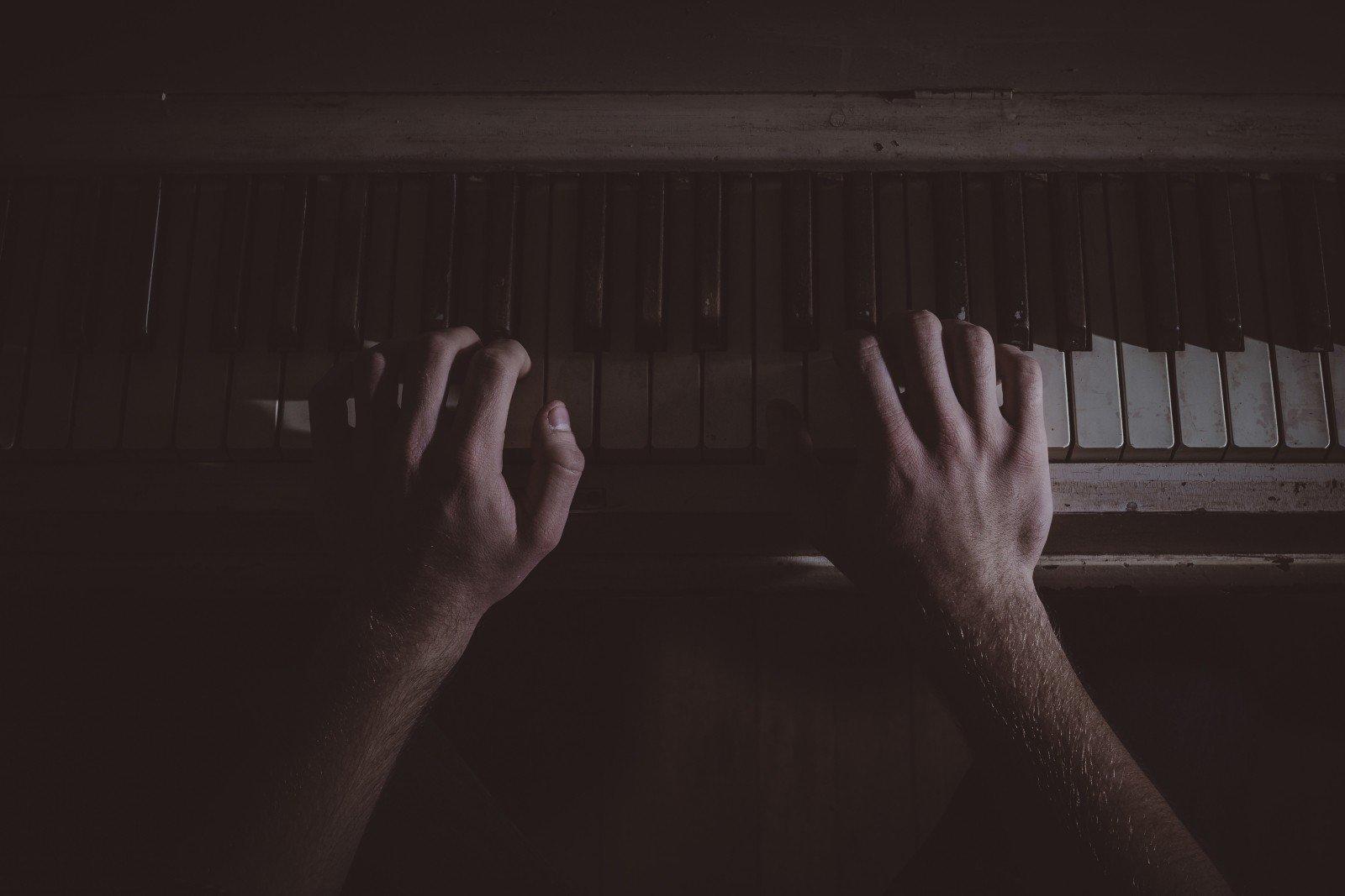Manos sobre piano de madera