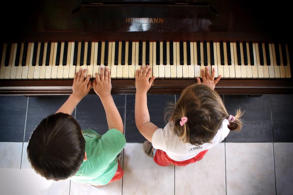 Niño y niña tocan piano