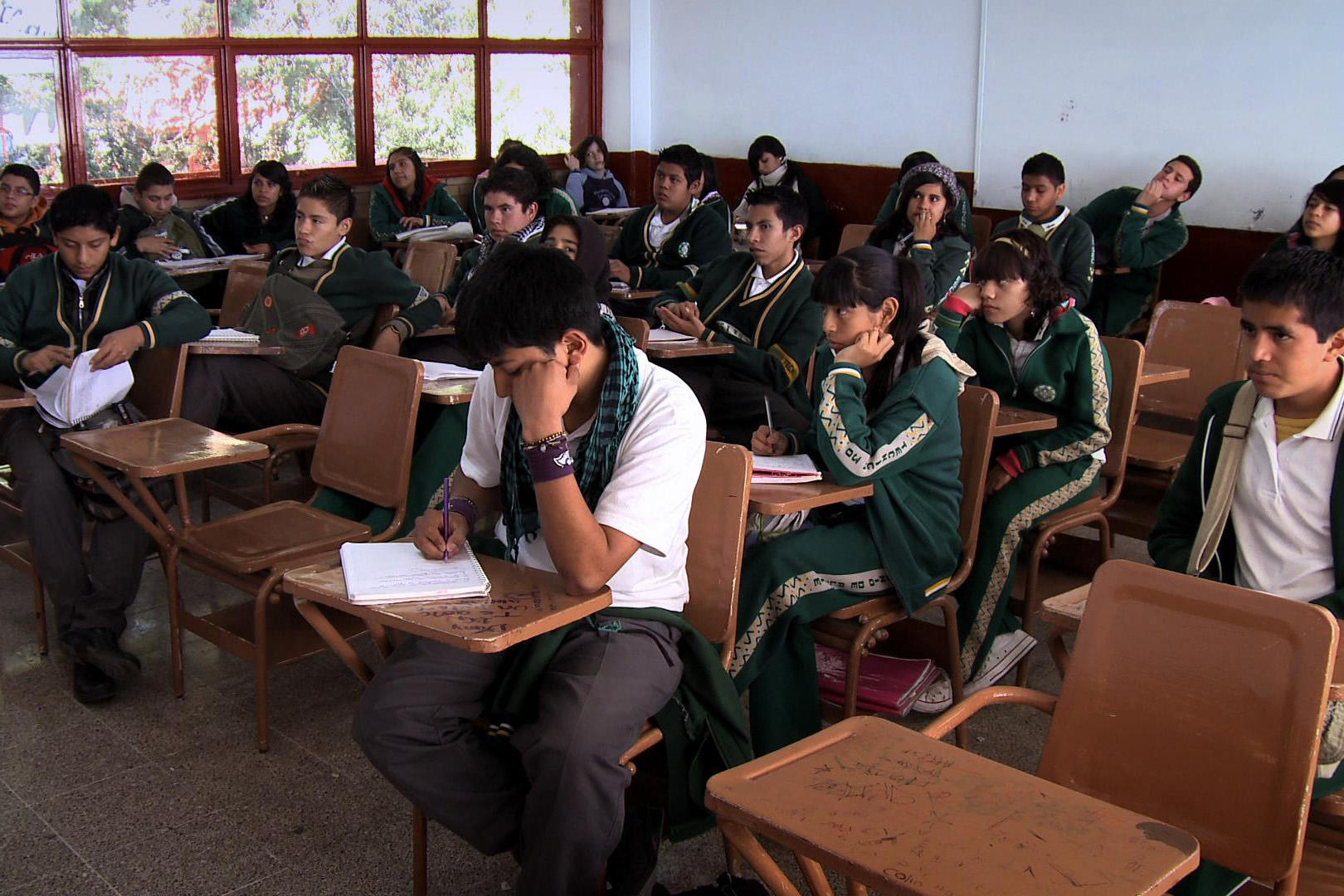 Sala de clases con estudiantes secundarios rindiendo evaluación