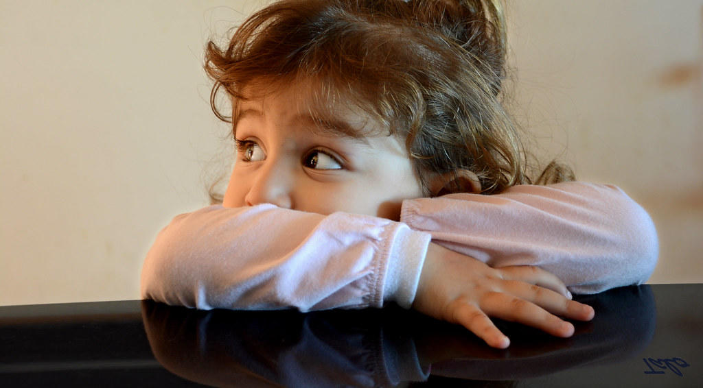 Niña apoyada en piano