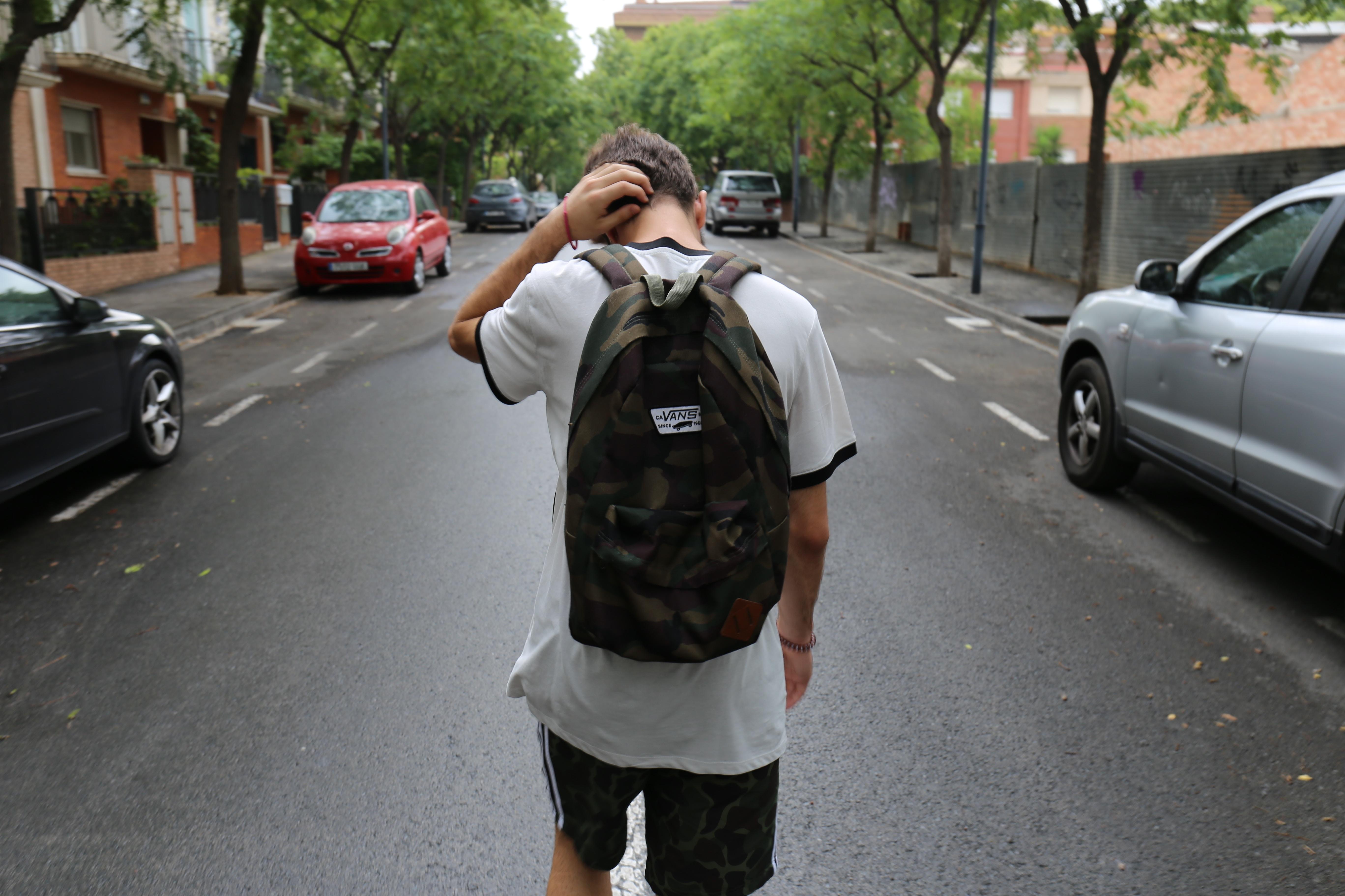 Estudiante camina por la calle cabizbajo
