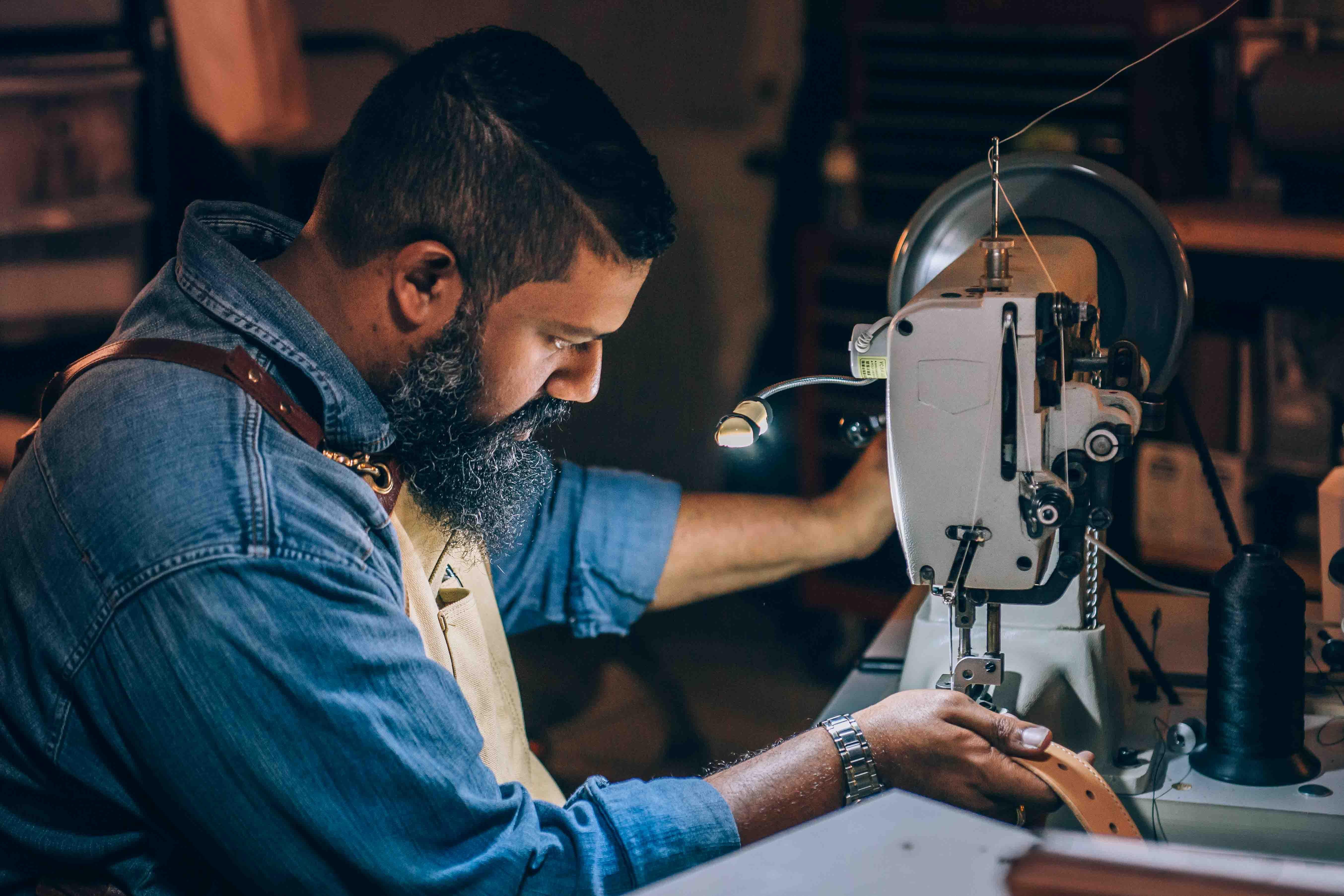 Máquina de coser y hombre usándola