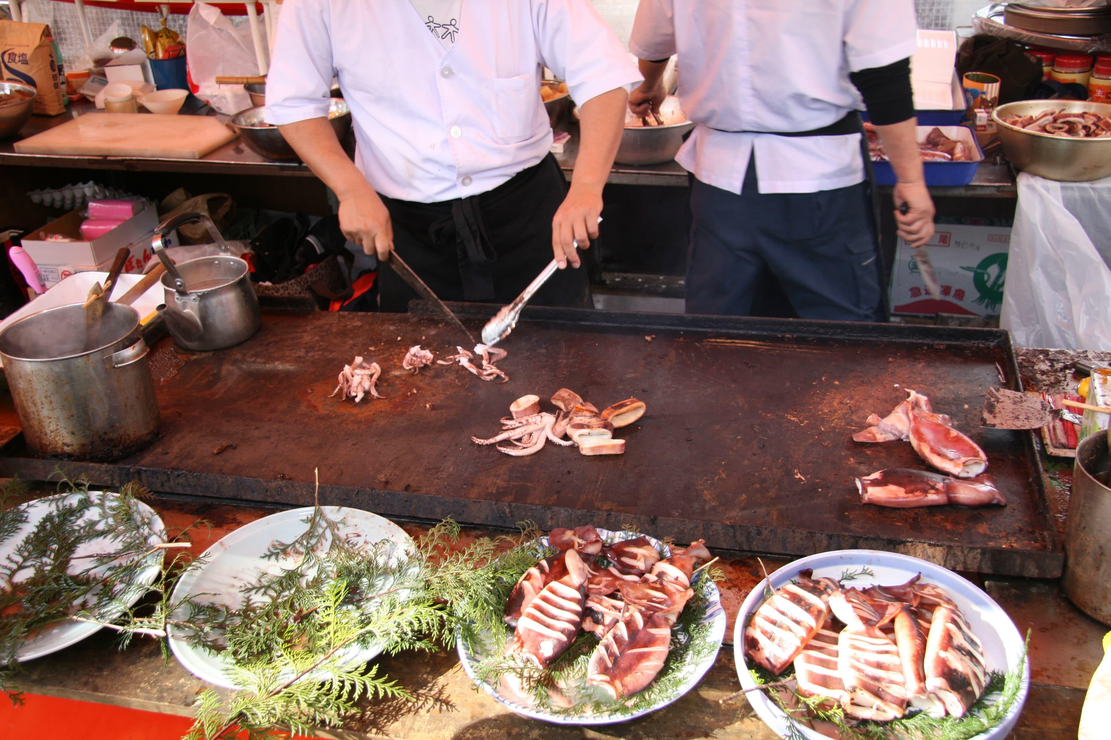 Cocineros preparan platos con carne