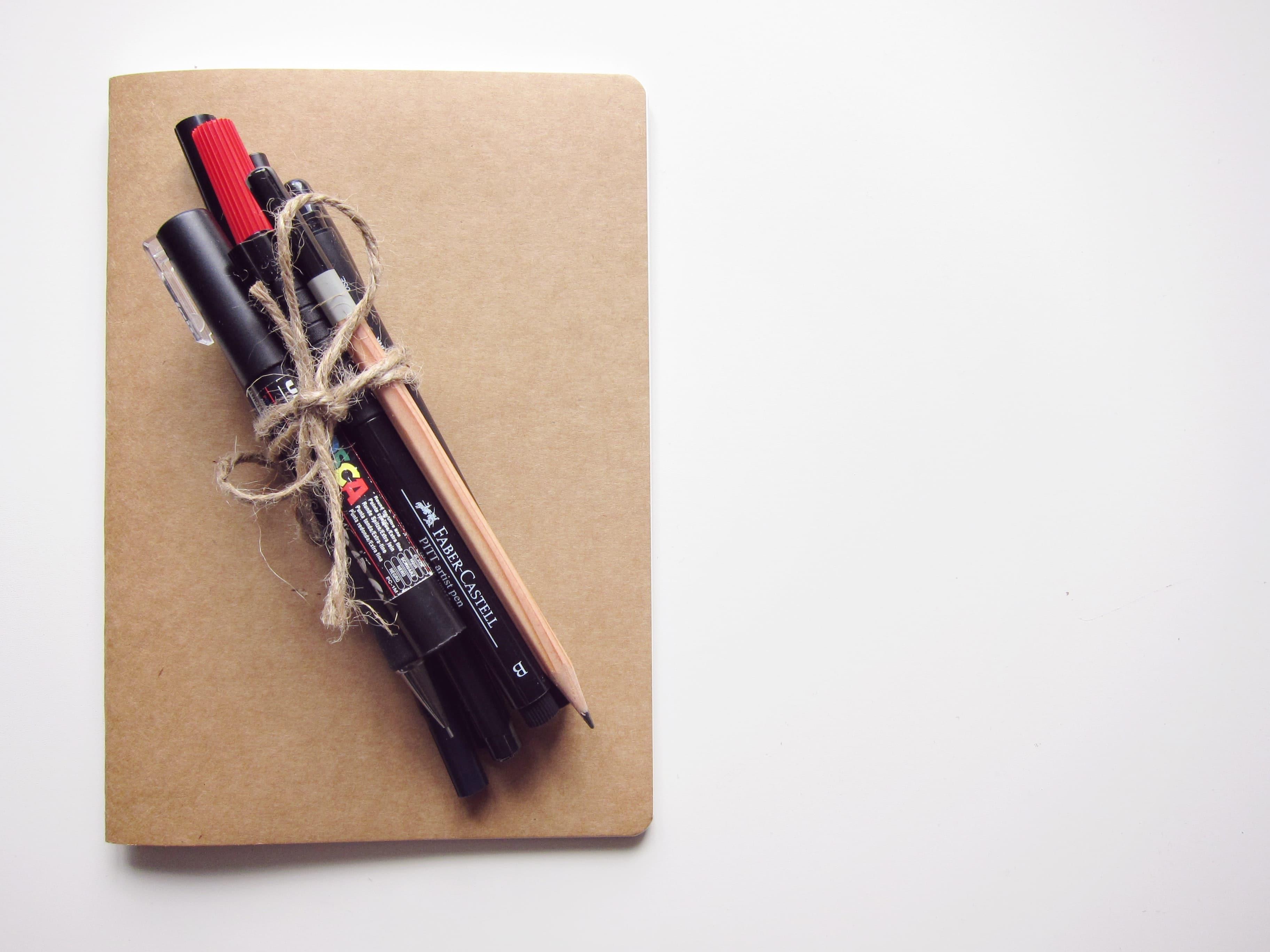 Cuaderno cerrado con lápices
