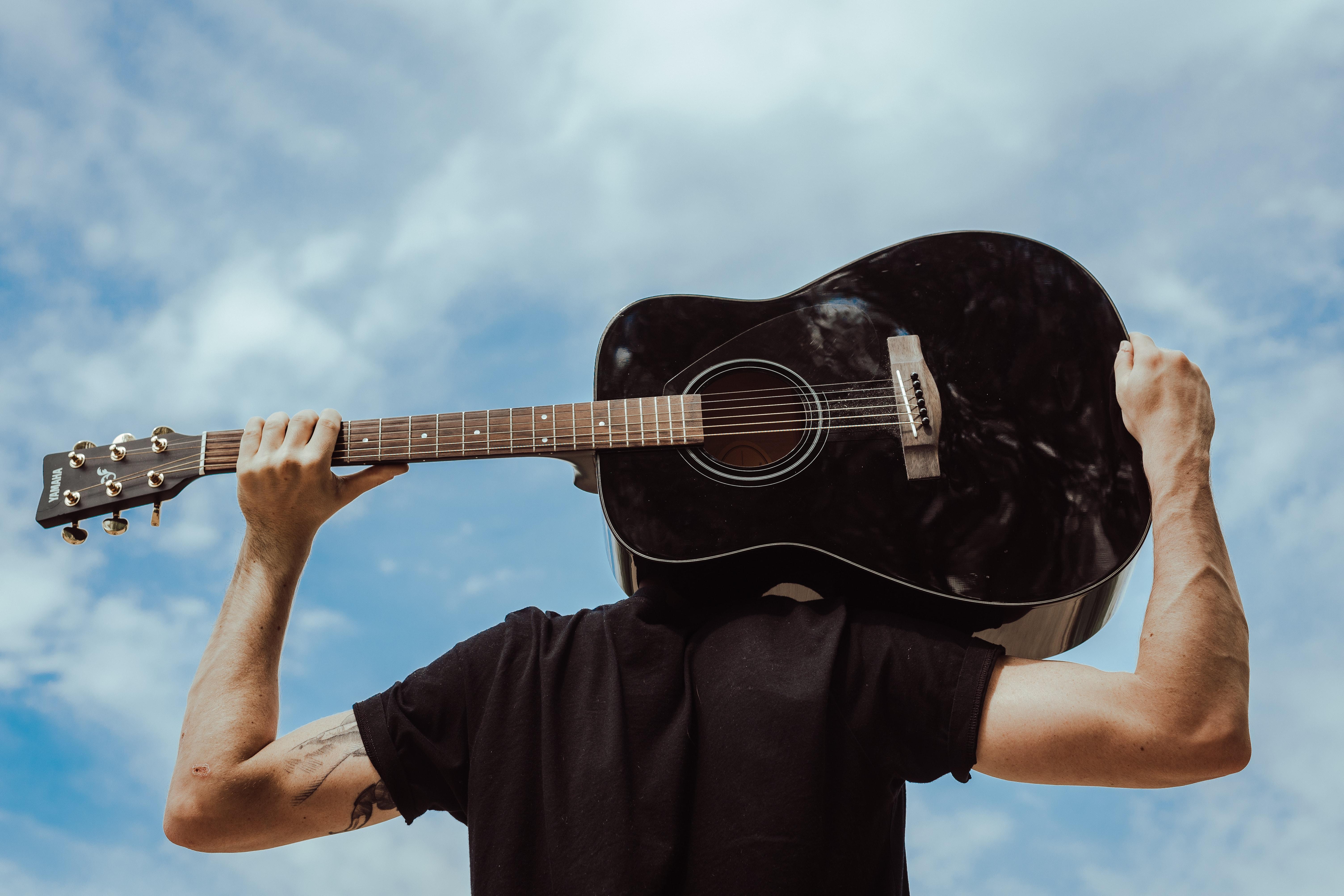 Persona con guitarra en la espalda