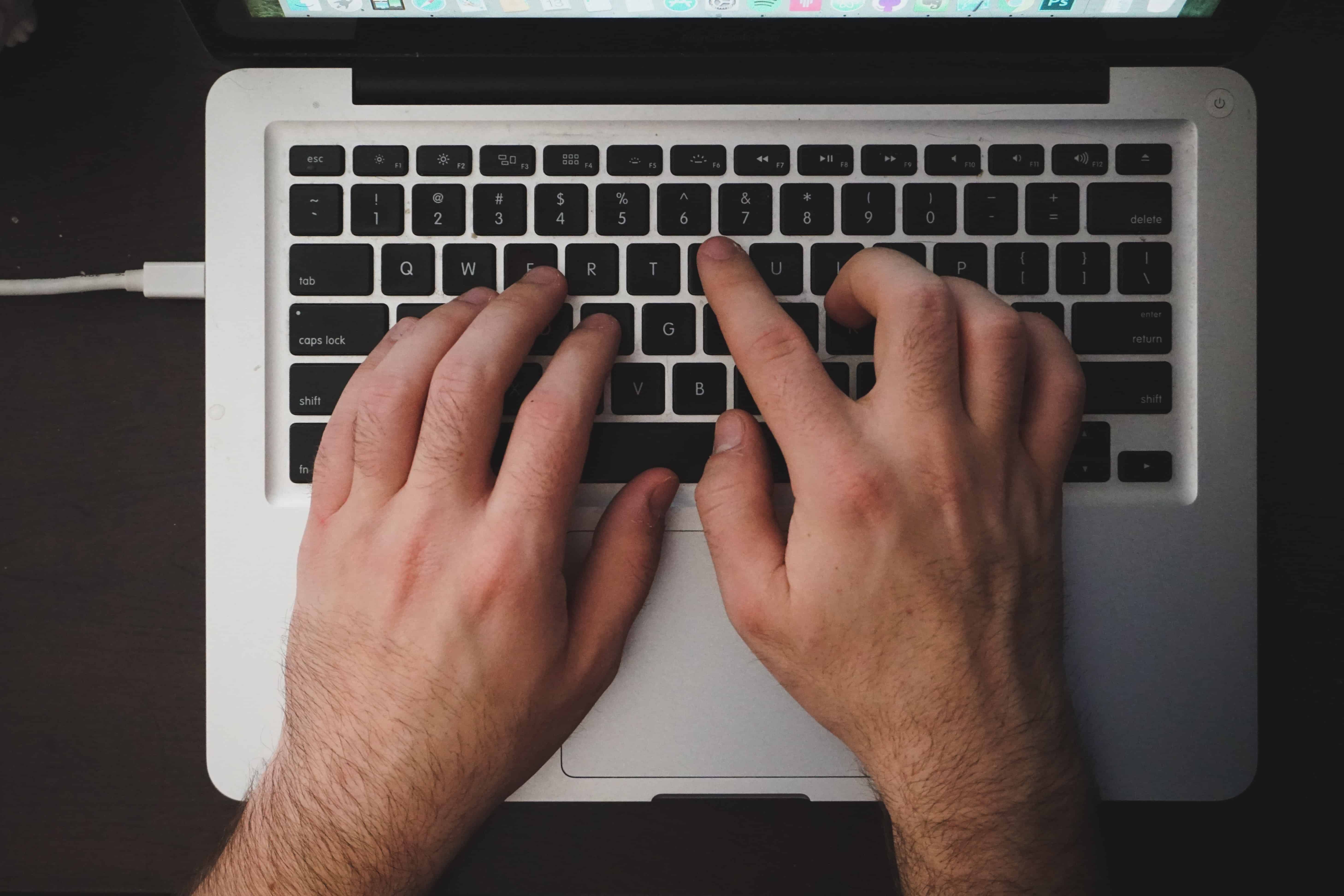 Manos de una persona escribiendo en computador portátil