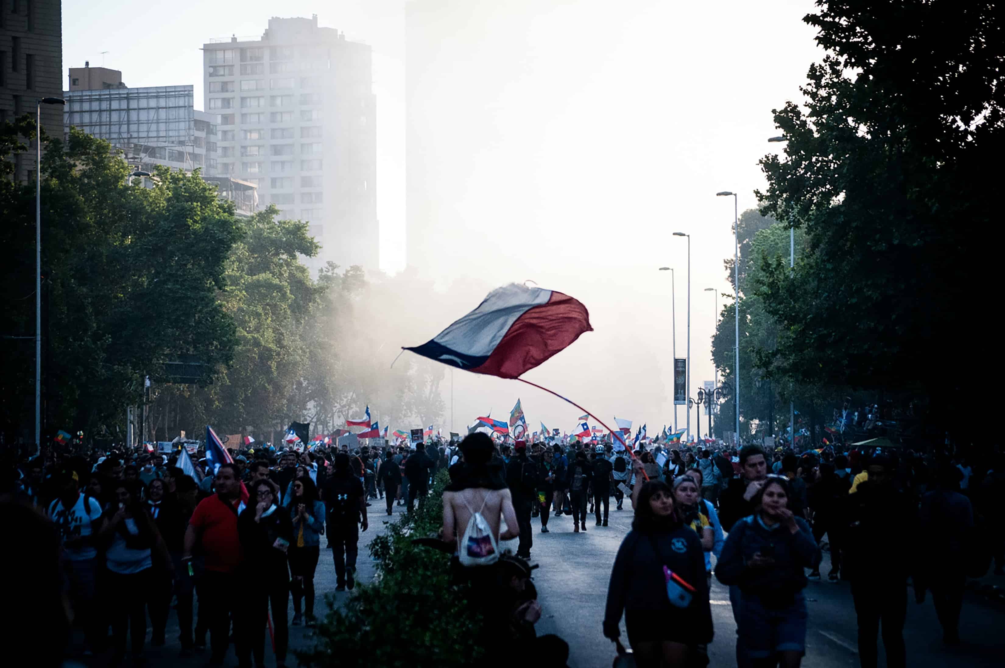 Protesta en medio de la calle y bandera chilena