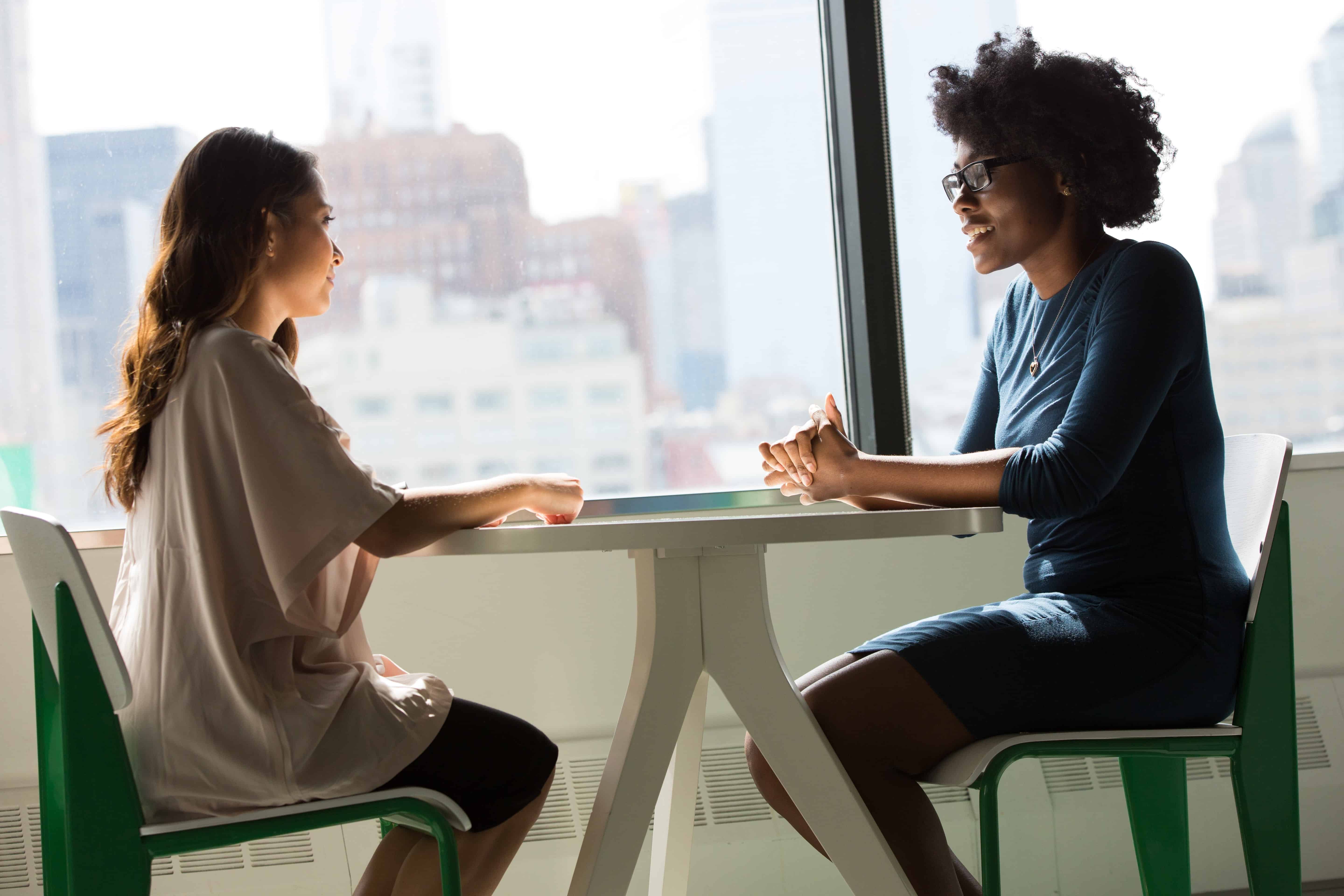 Psicóloga y estudiante conversando en una mesa de café