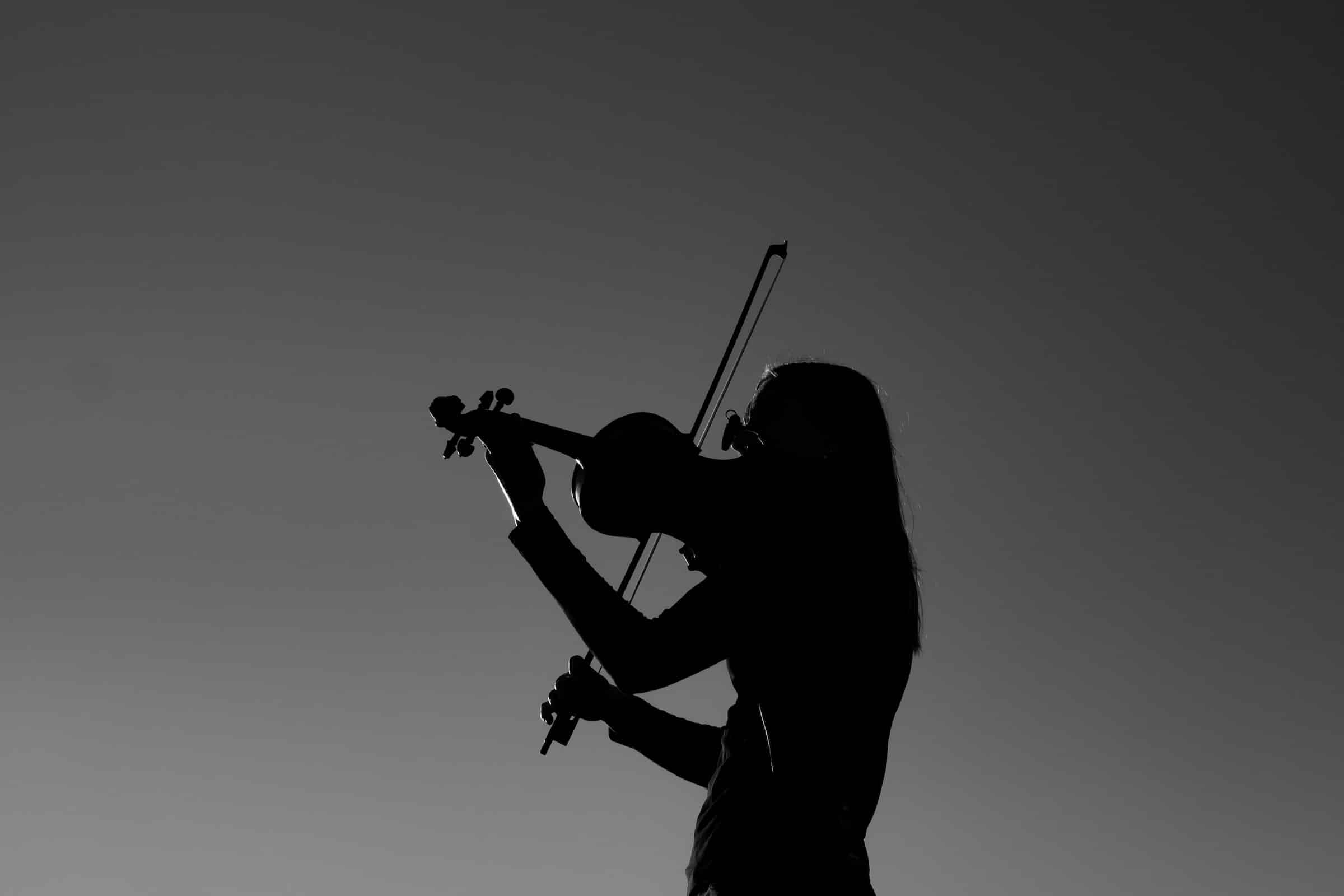 Silueta de violinista con violín a contraluz