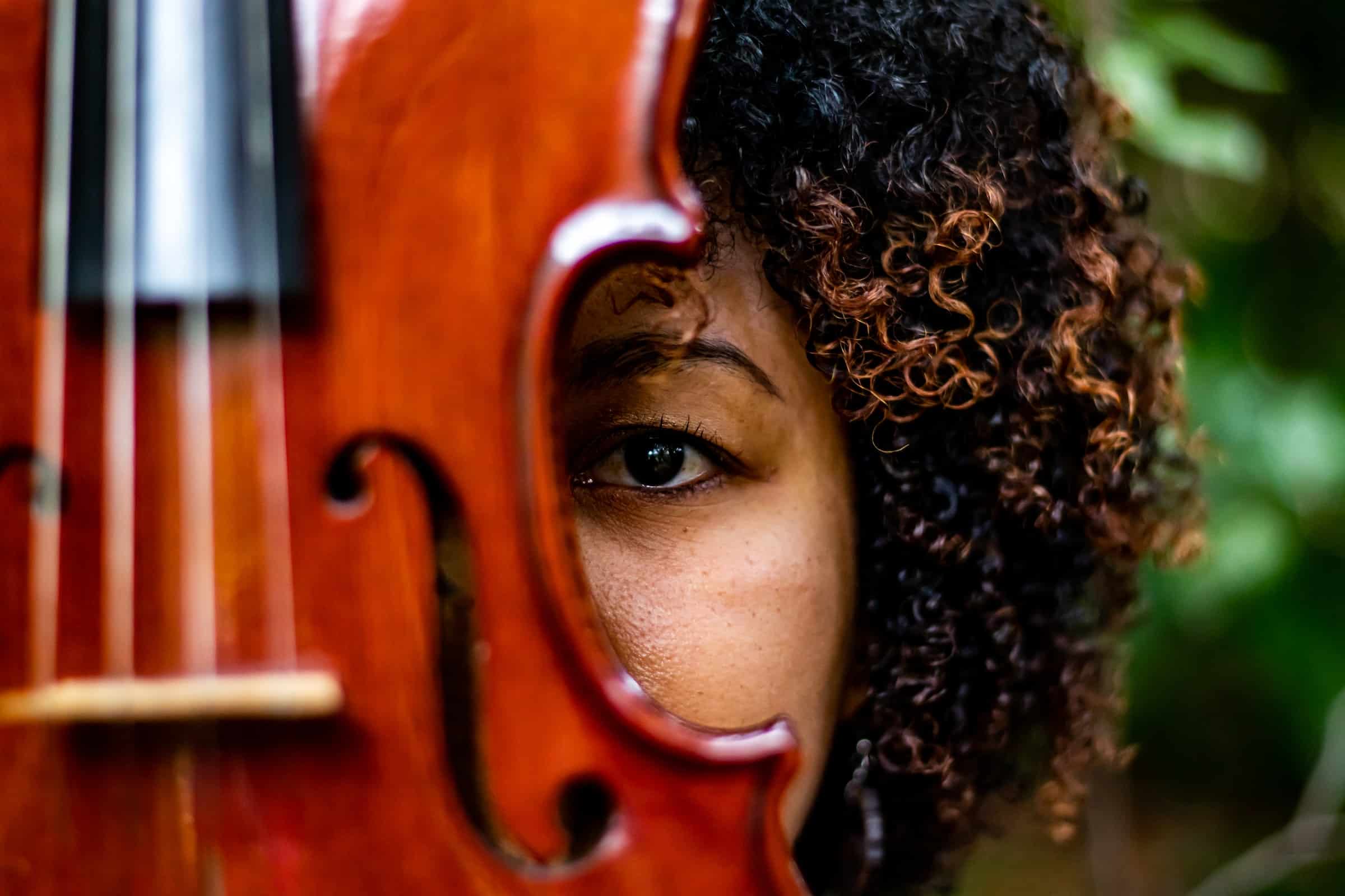 Rostro de una persona detrás del violín en primer plano