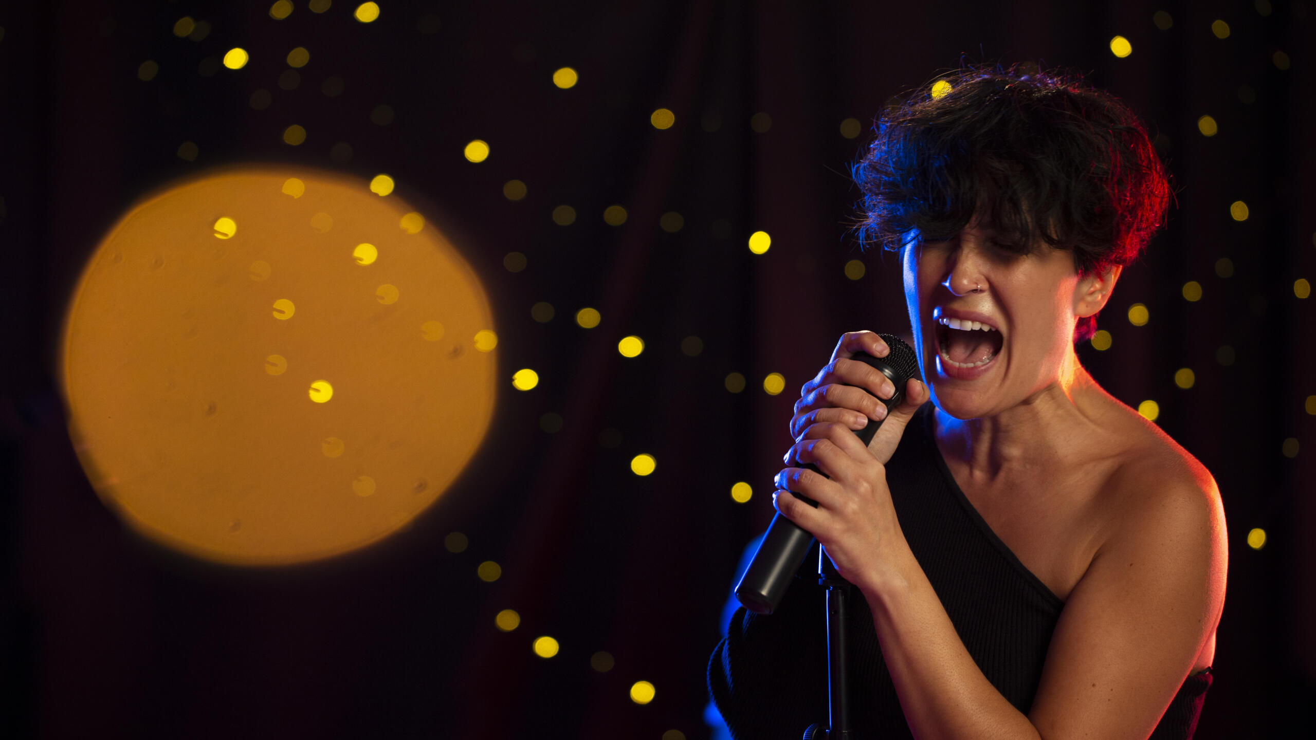 mujer interpretando una canción a viva voz sobre el escenario