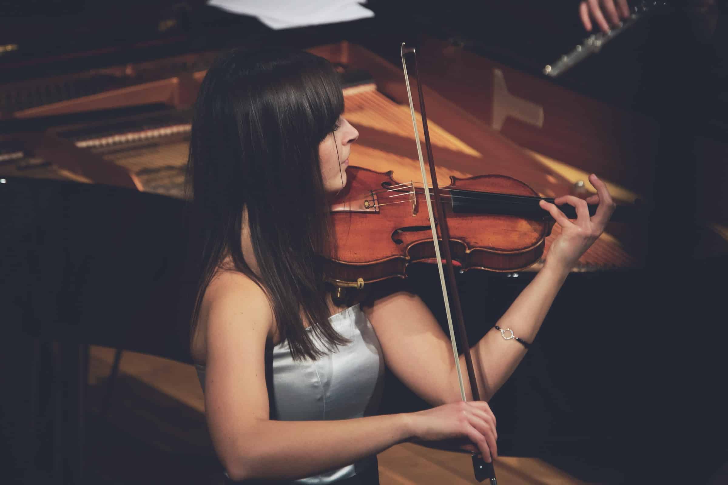 Violinista en medio del escenario tocando el instrumento