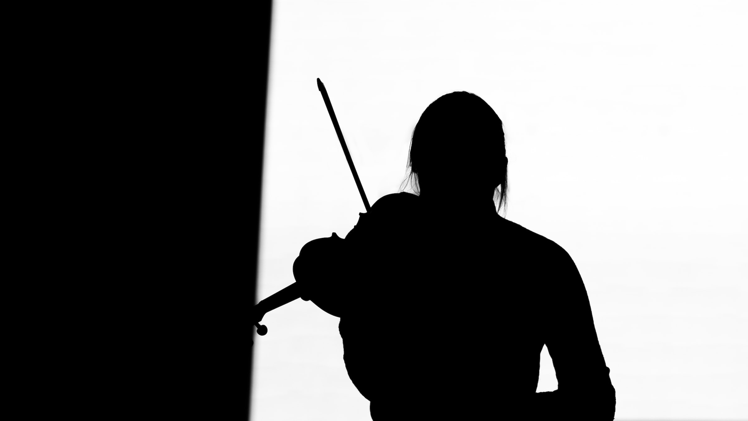 Mujer con violín a contraluz