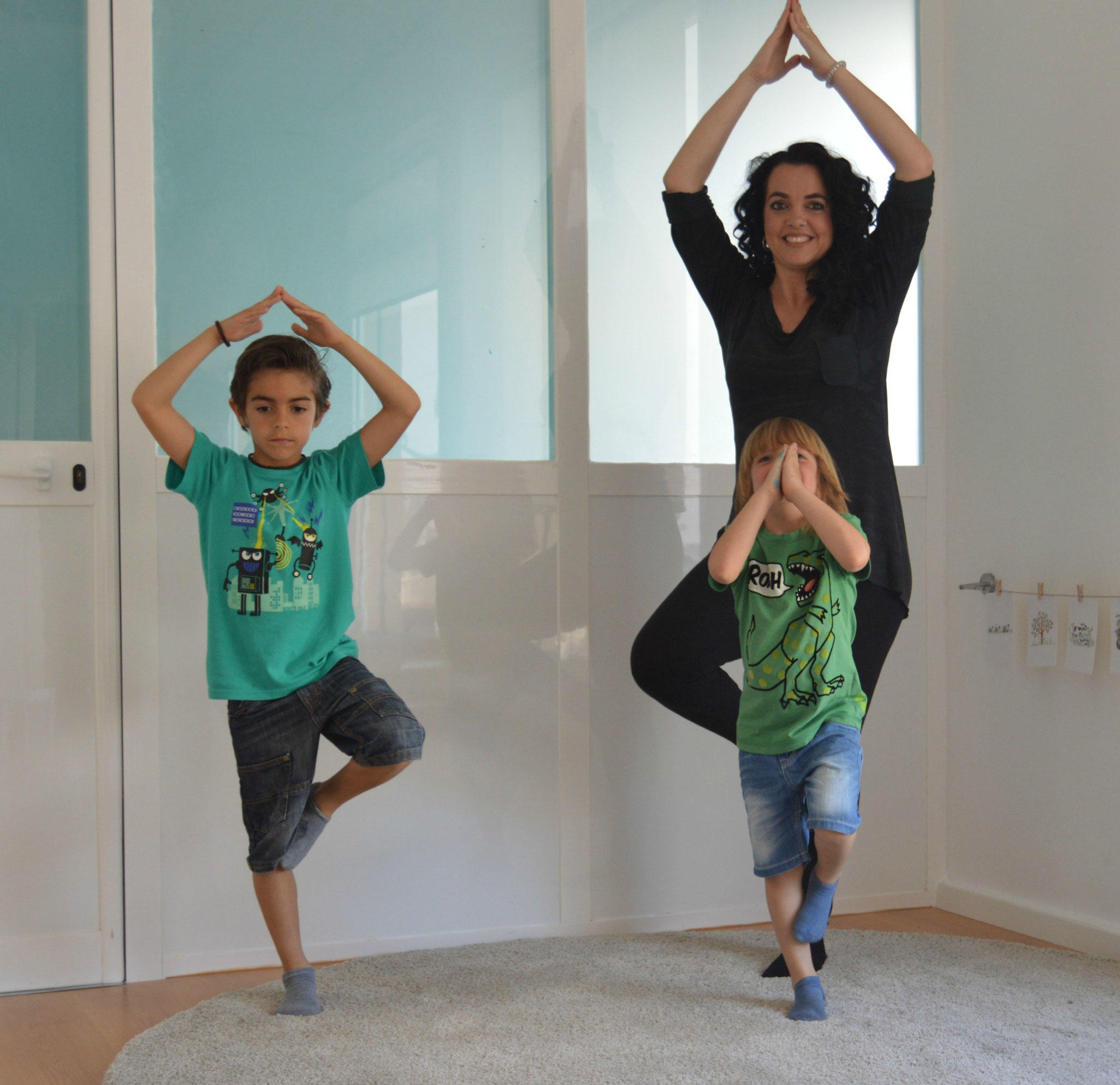 Mamá e hijos practicando yoga.
