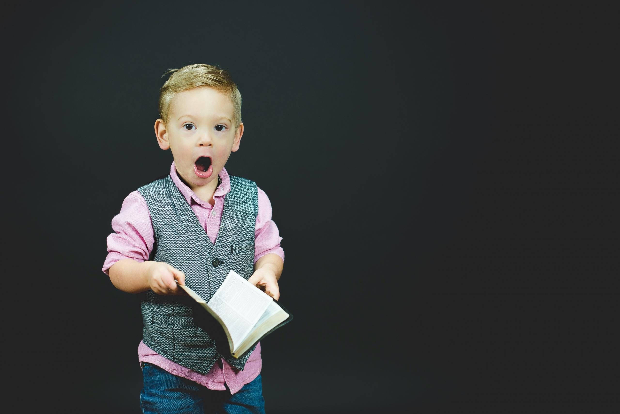 Niño sosteniendo un libro.