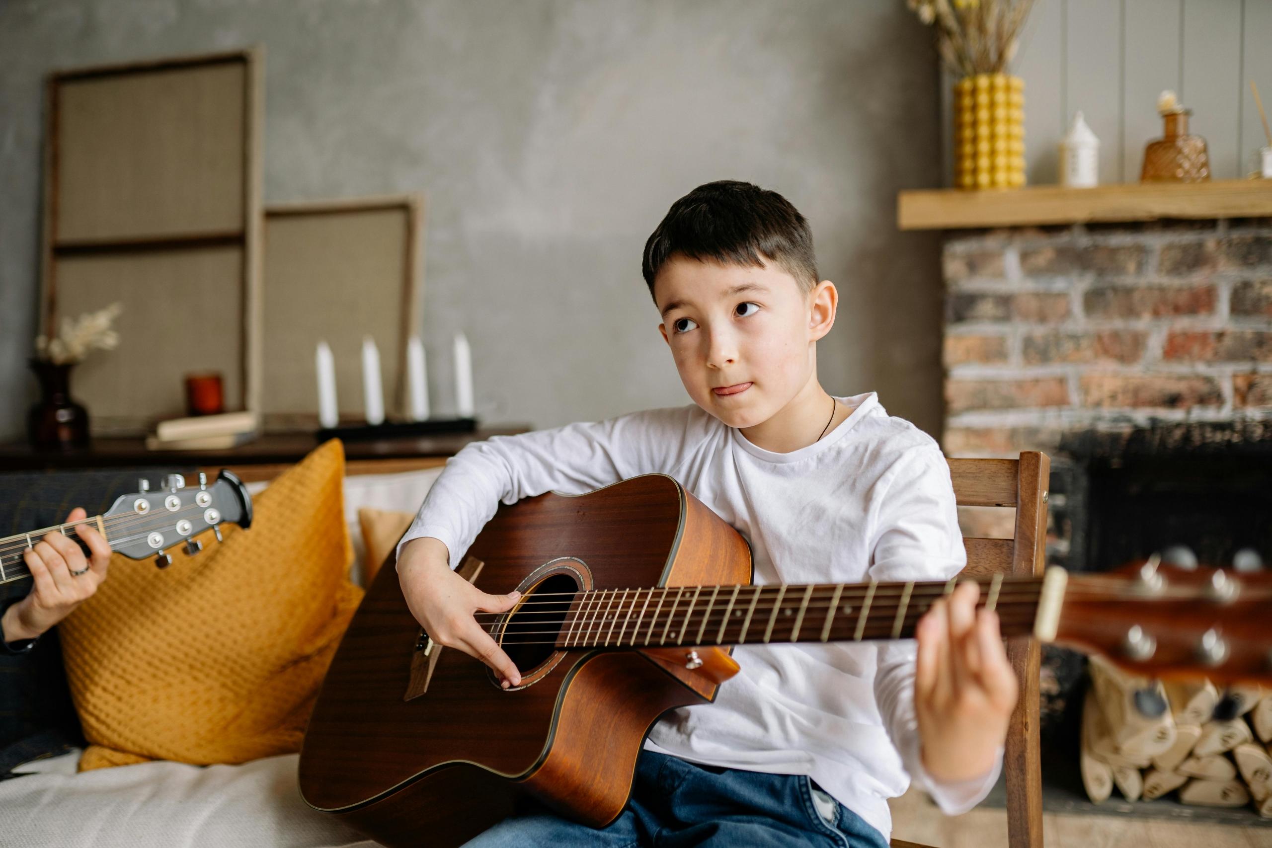 Un niño aprendiendo guitarra.