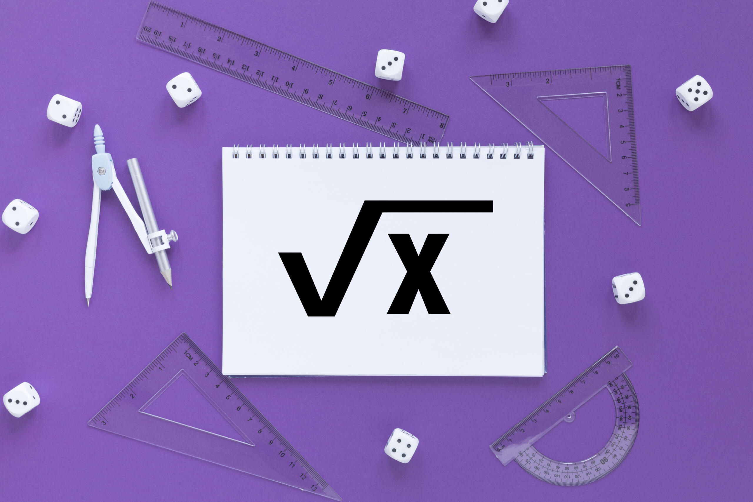 vista cenital de un cuaderno con la raiz cuadrada de x y reglas, dados y un compas alrededor en fondo lila