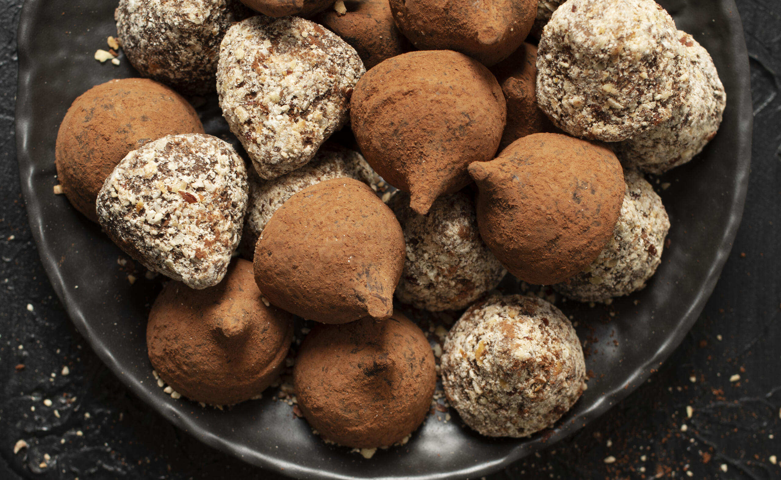 toma cenital de un bowl lleno de trufas de chocolate con coberturas de cacao y azúcar flor