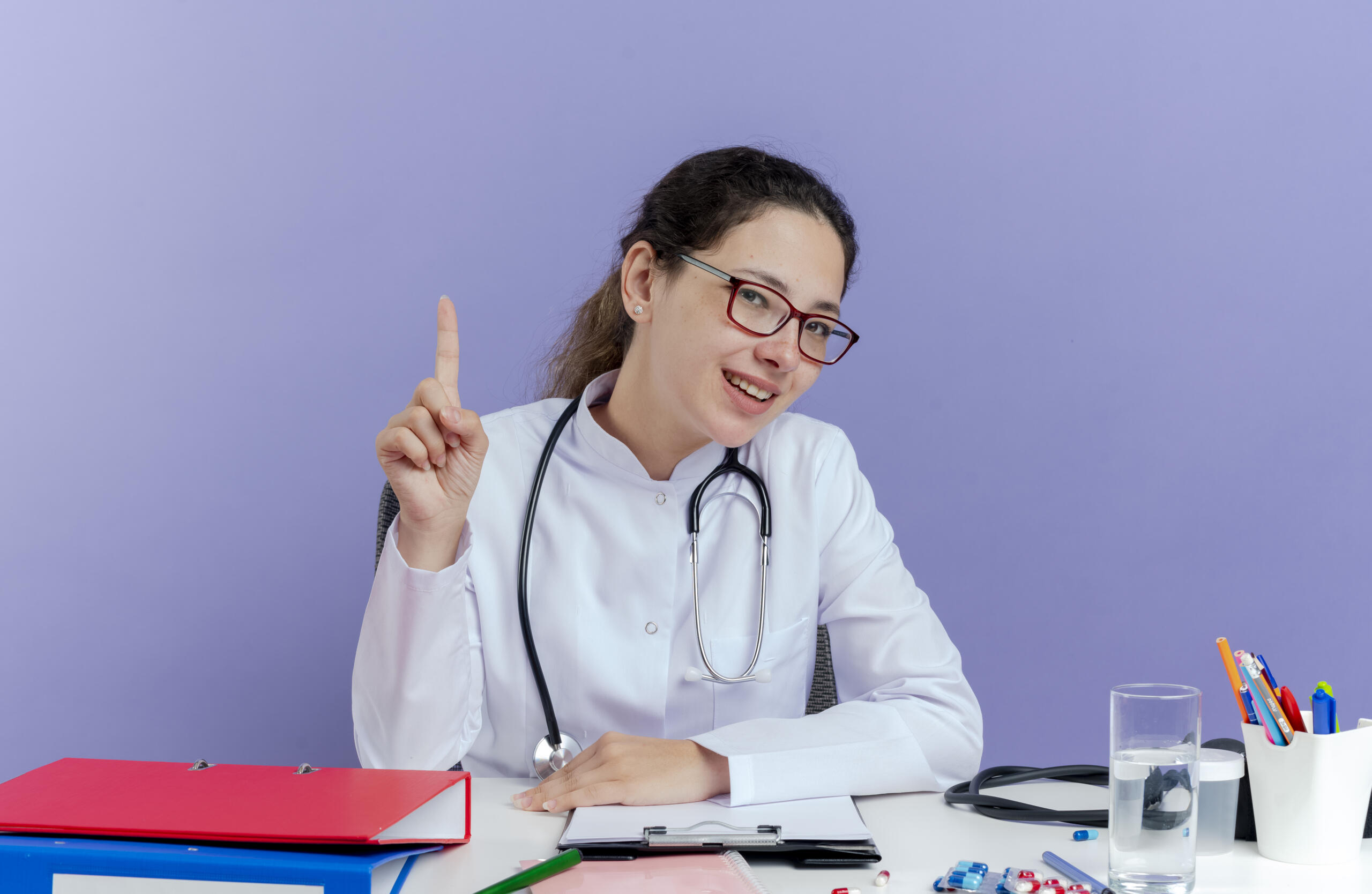 Chica sentada utilizando un uniforme de medicina con estetoscopio.