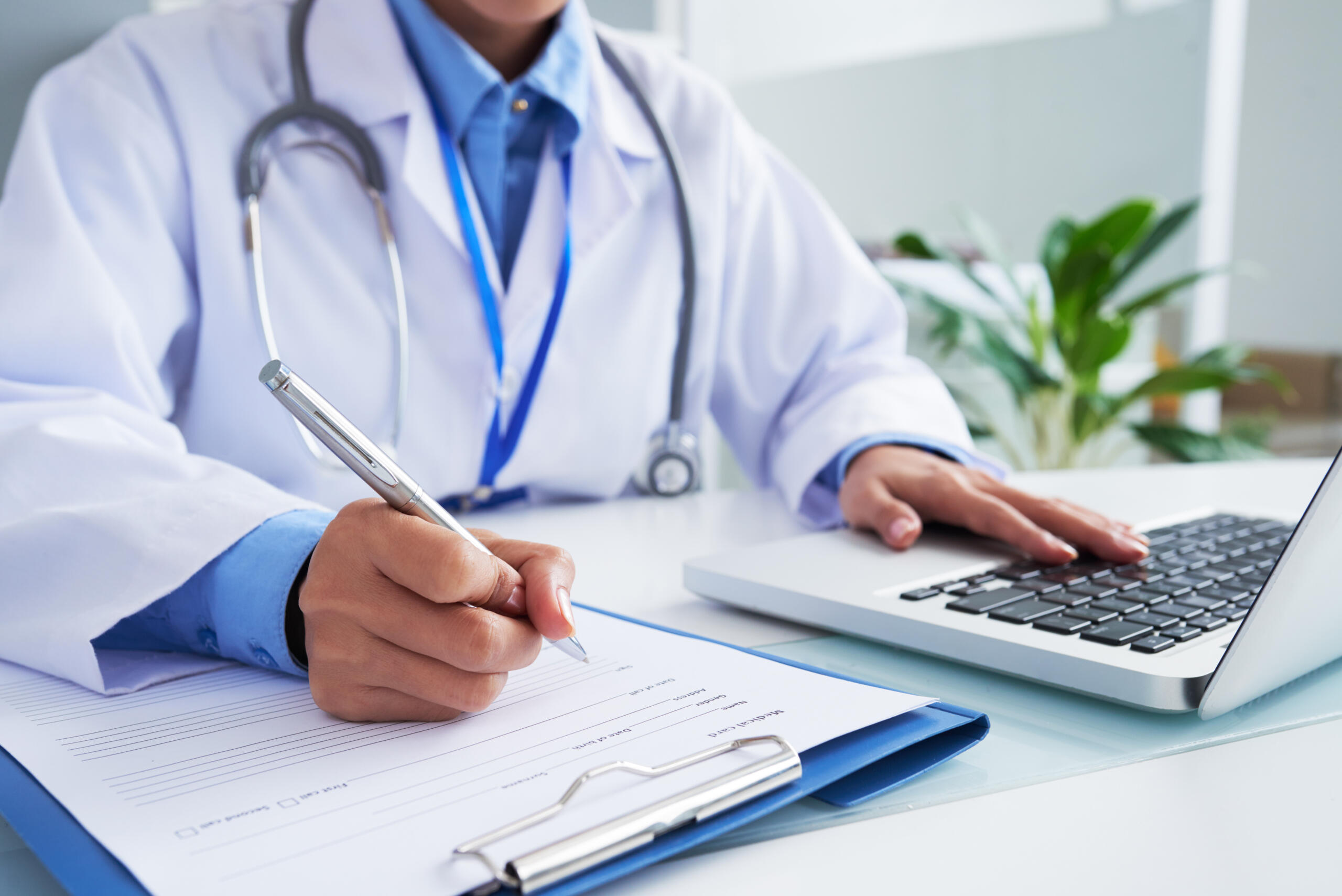 Doctor llenando una forma durante consulta médica