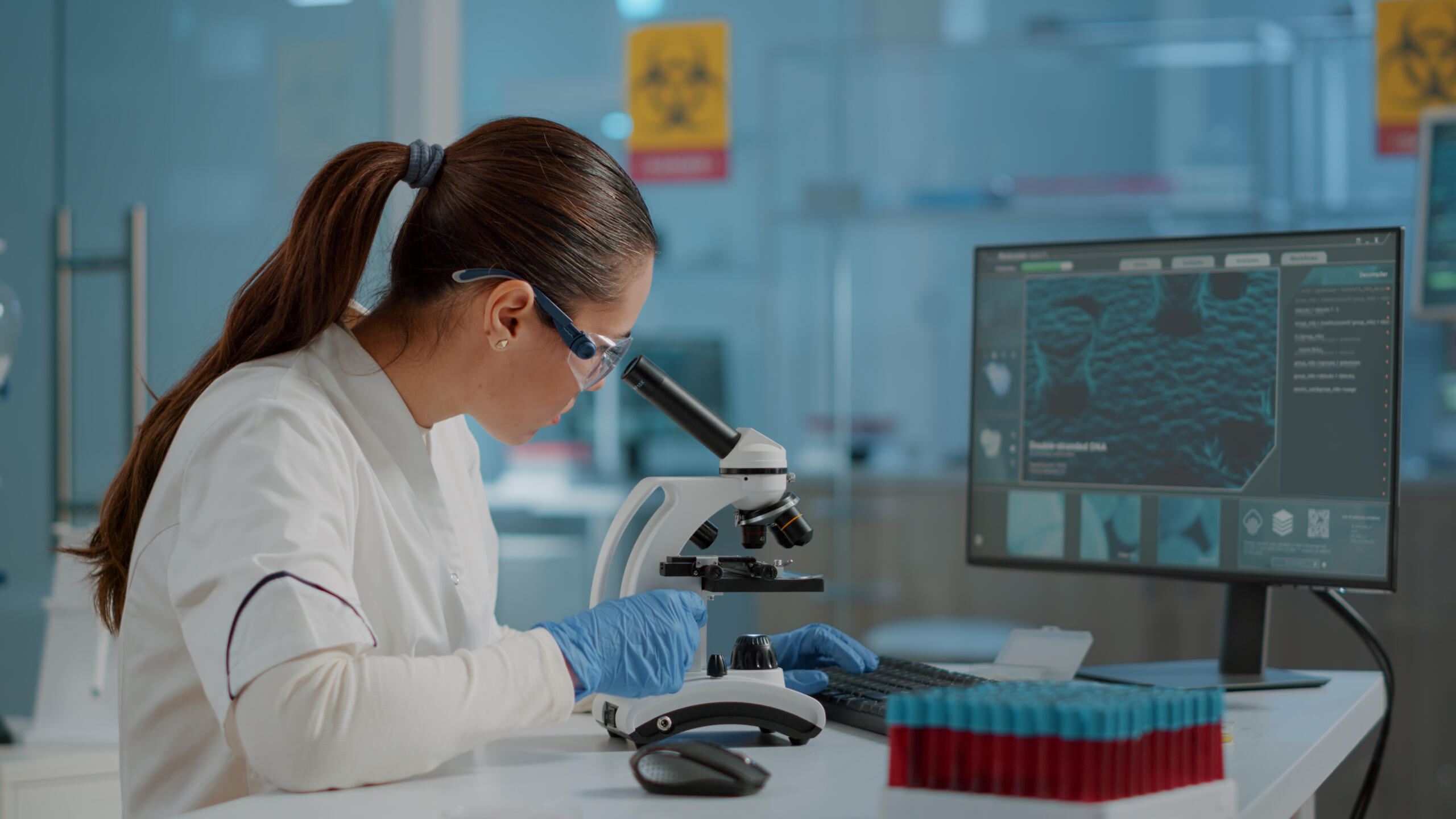 Doctora viendo a través de un microscopio