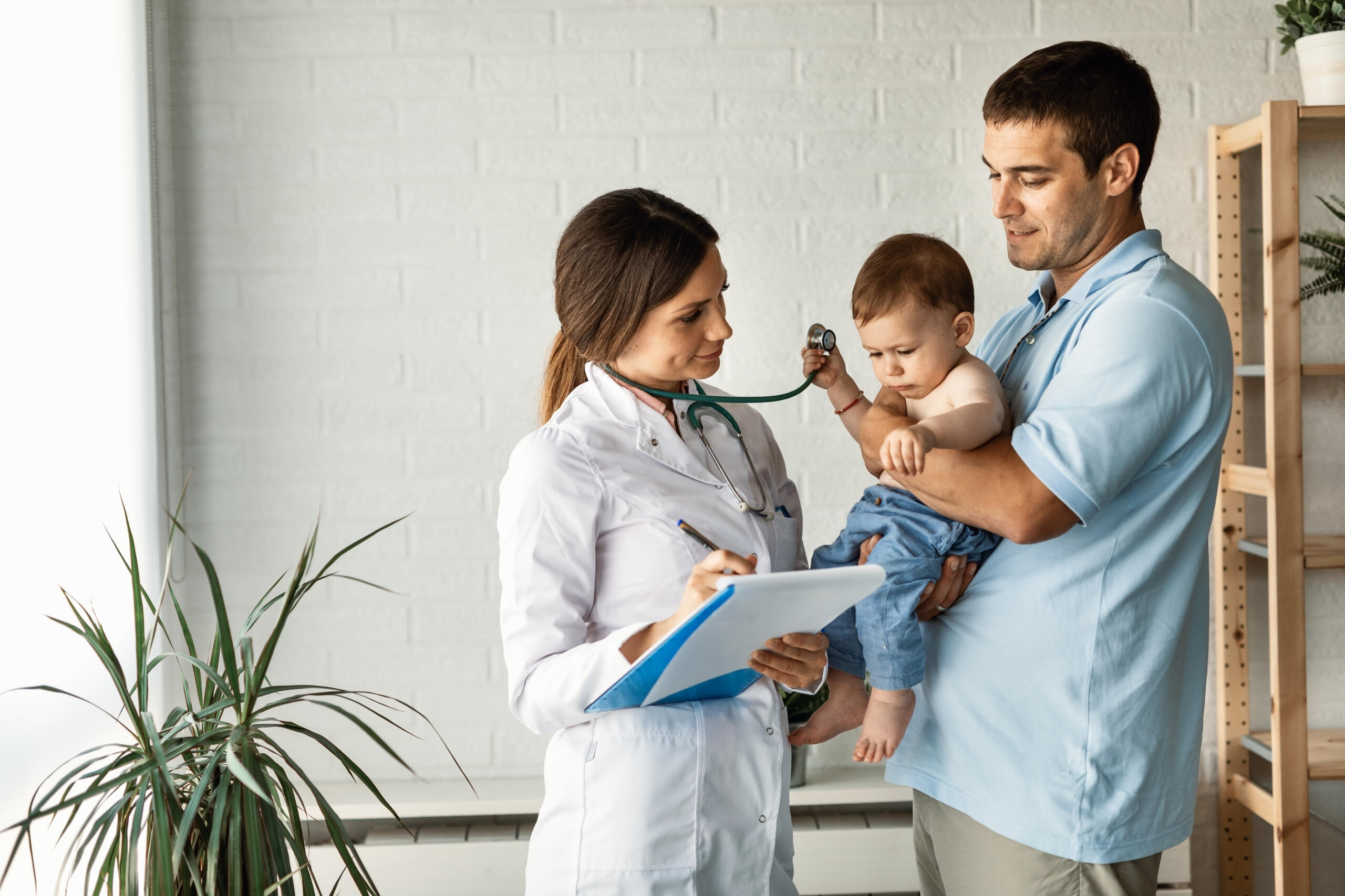 Médica atendiendo a un padre y su bebé
