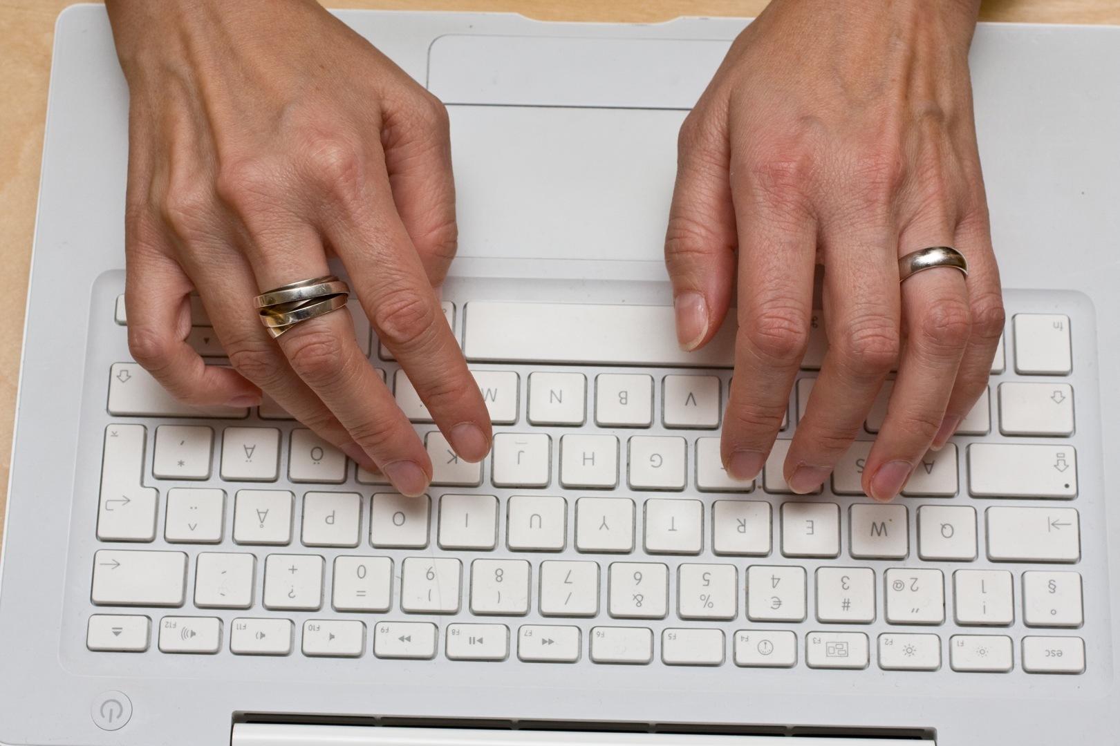 Manos escribiendo en un teclado de compuatdora.