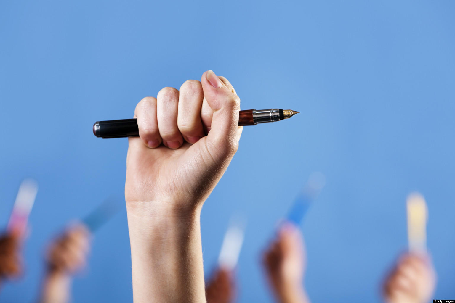 Mano levantada mientras sostiene un lápiz.