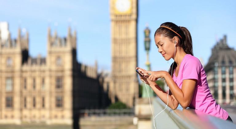 Chica escuchando música desde su celular en el puente de Londres