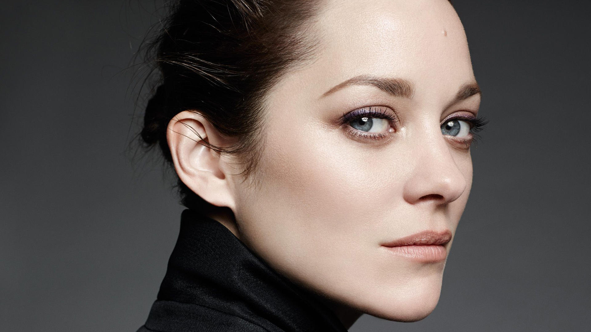 La actriz Marion Cotillard viendo de perfil.