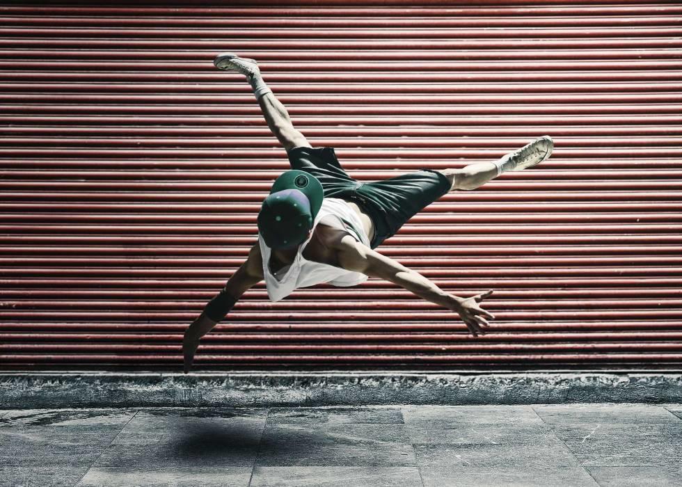 Hombre haciendo movimiento de acrobacia de baile contemporáneo, suspendido en el aire