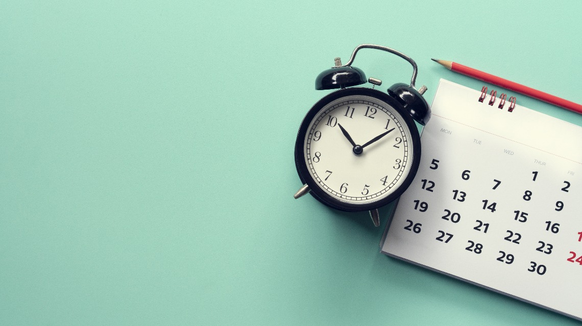 Reloj, junto a un calendario.