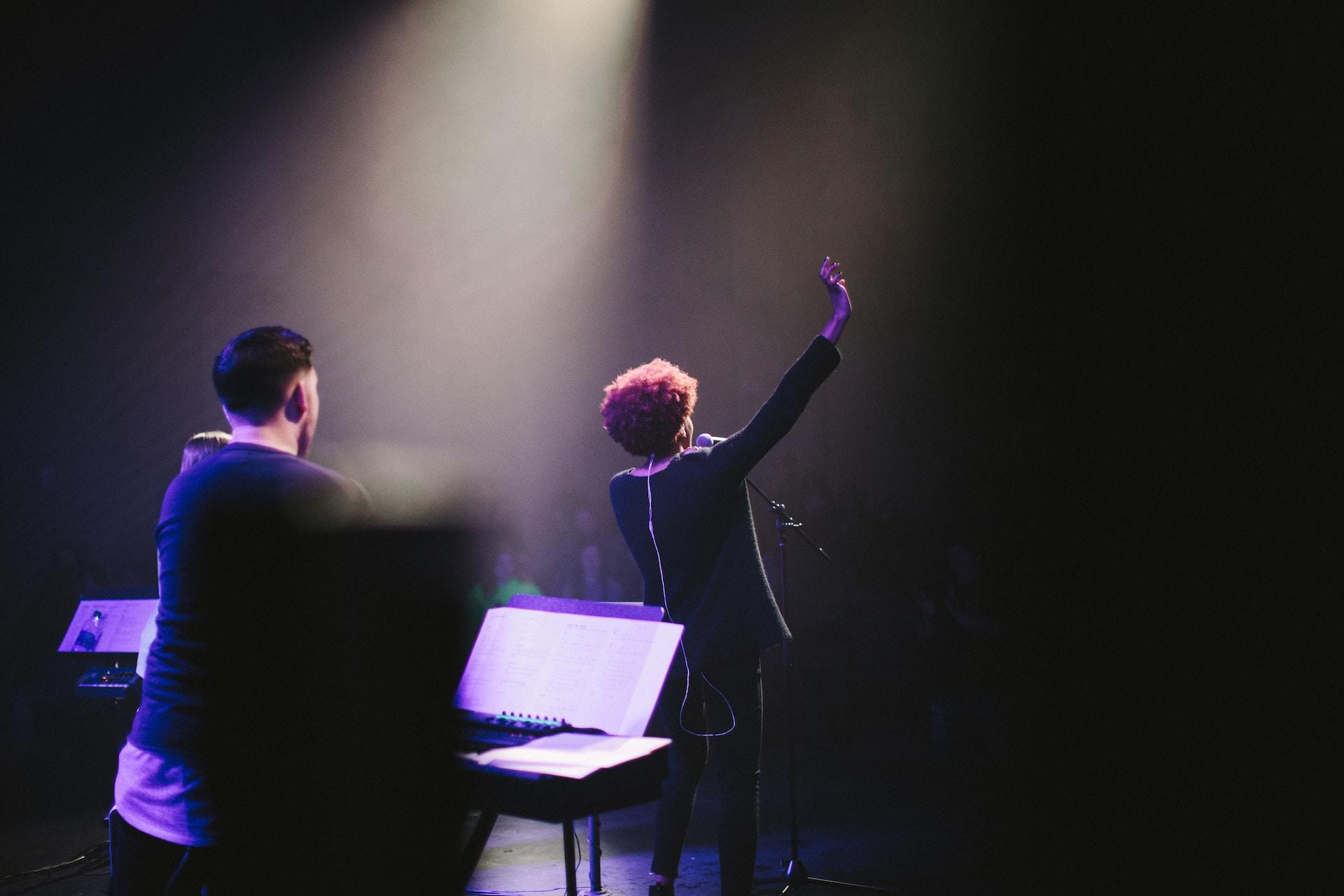 Mujer cantante acompañada por pianista en escena