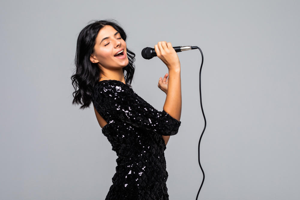 Mujer vista de perfil con vestido negro cantando