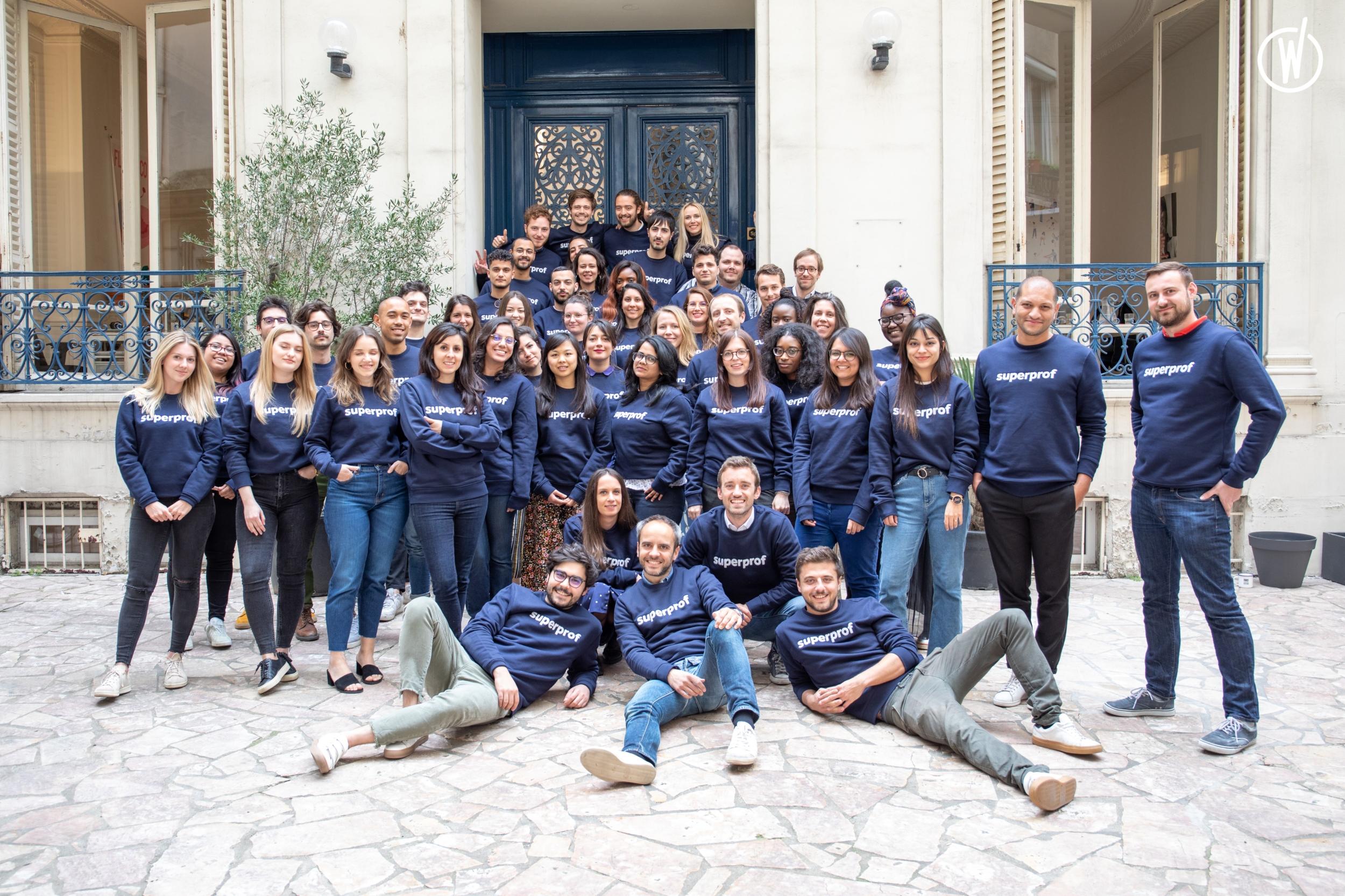Varias personas posando para una foto a las afueras de una casa, todos con un sweater institucional de Superprof