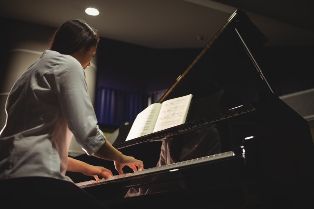 Chica tocando piano leyendo a primera vista