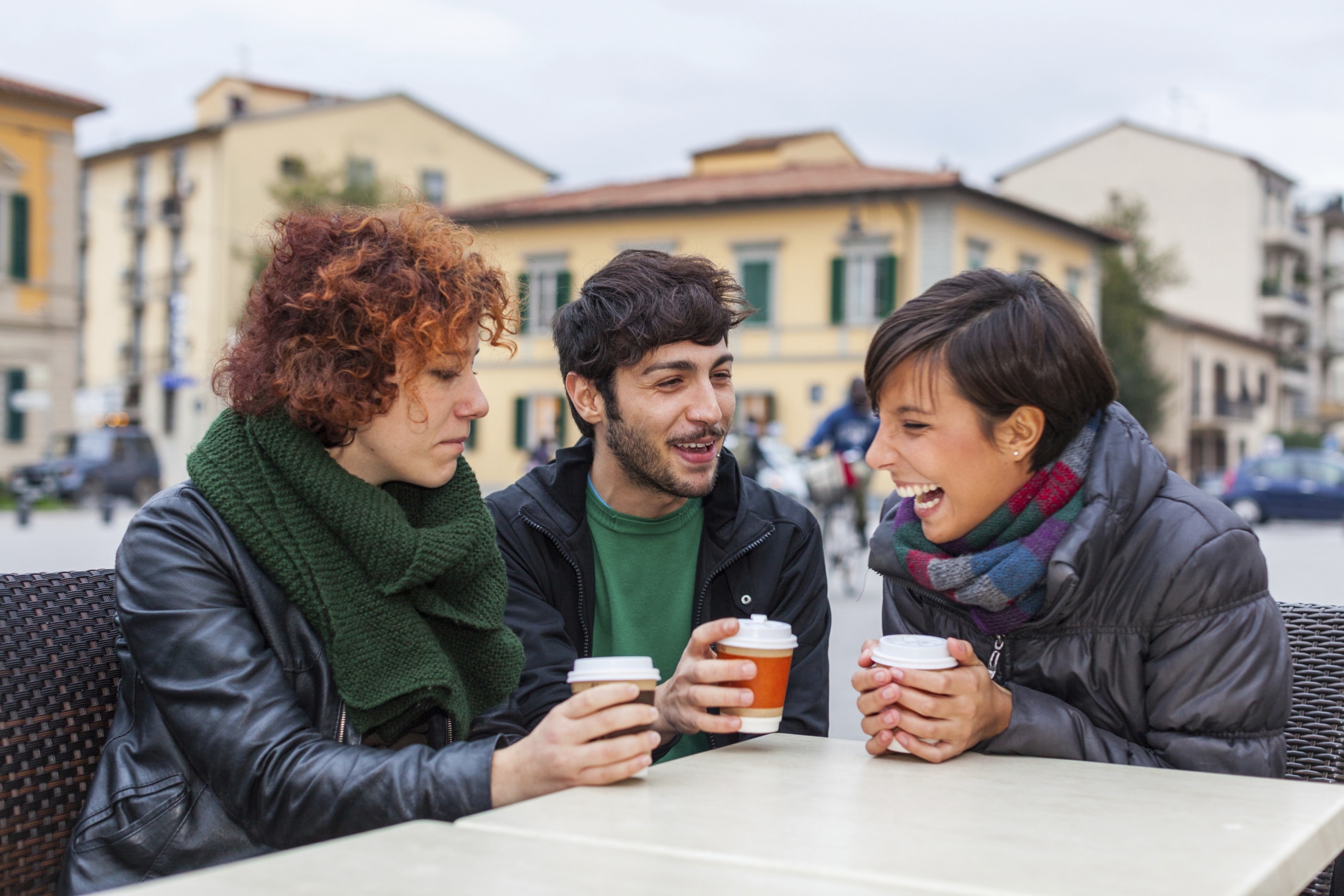 Personas hablando, mientras toman un café, sentados a la mesa.