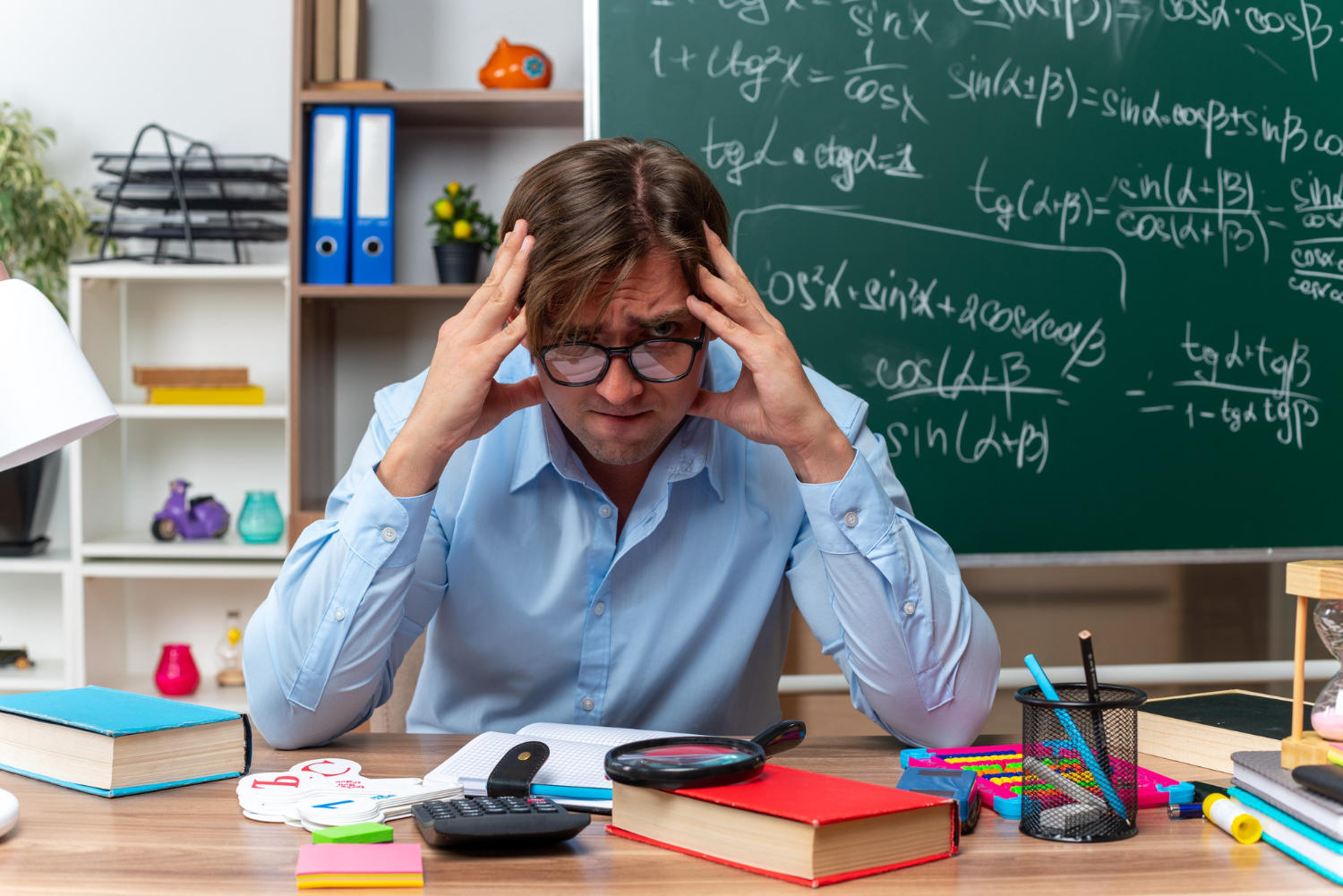 Profesor con estrés al no poder resolver problemas matemáticos