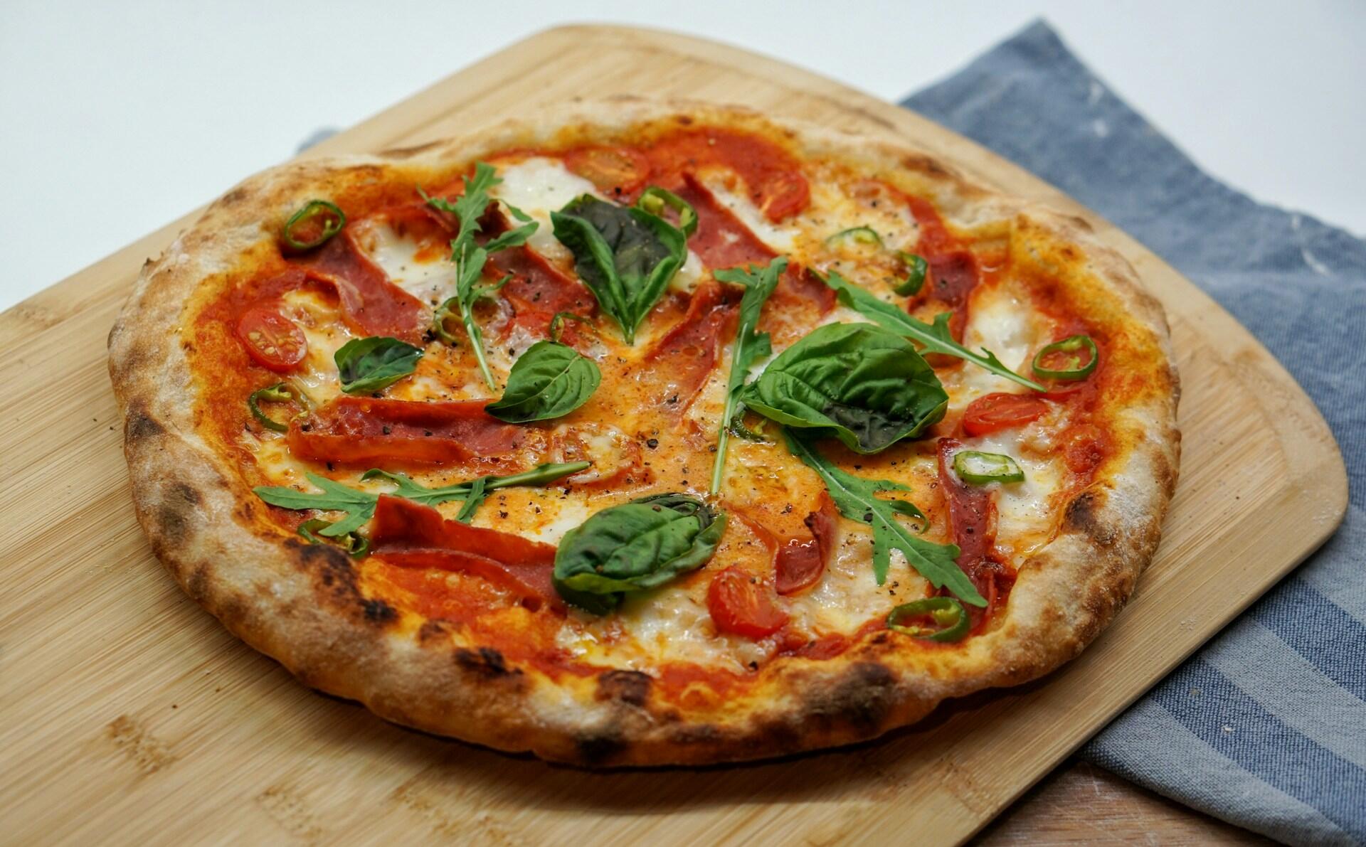 Originaria de Nápoles, la pizza margarita se elabora con una base de masa fina, salsa de tomate, mozzarella de búfala, albahaca fresca y un chorrito de aceite de oliva