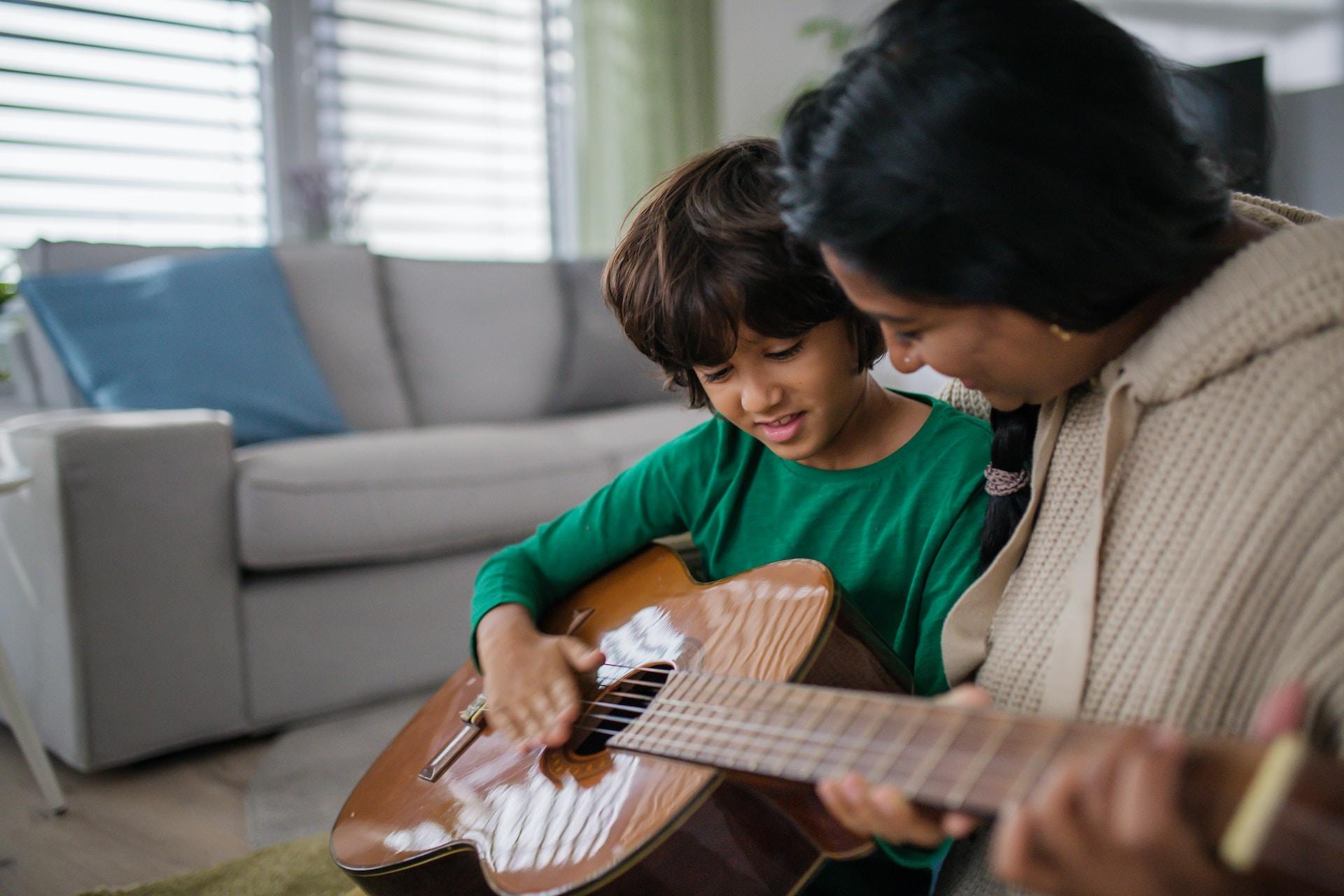 Profesora en clase de guitarra con un niño