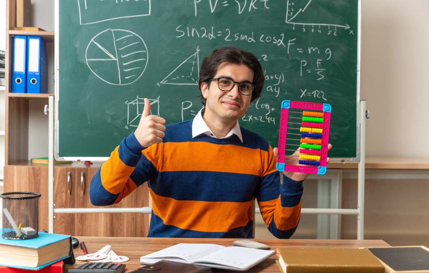 Joven profesor sosteniendo un ábaco frente a un tablero
