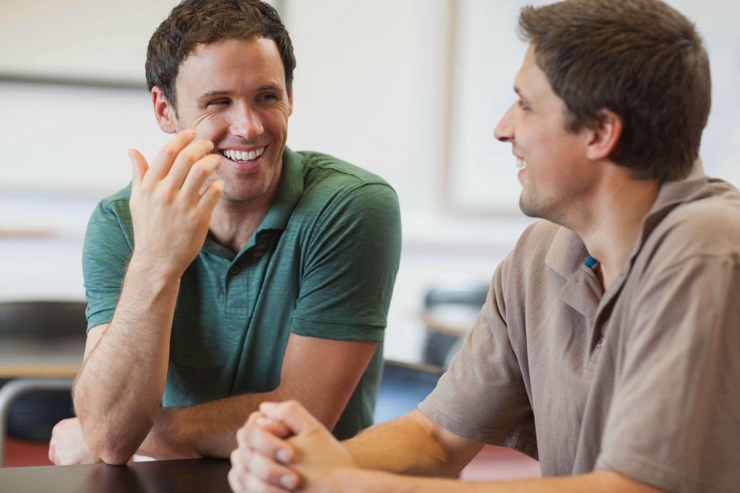 Hombres sonriendo mientras dialogan.
