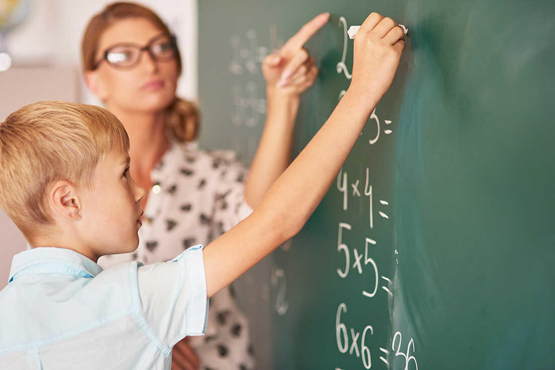Profesora particular enseñando matemáticas a un niño.