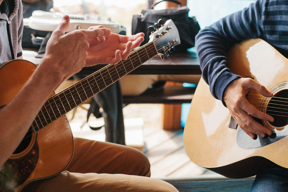 Dos jóvenes interpretando cada uno una guitarra