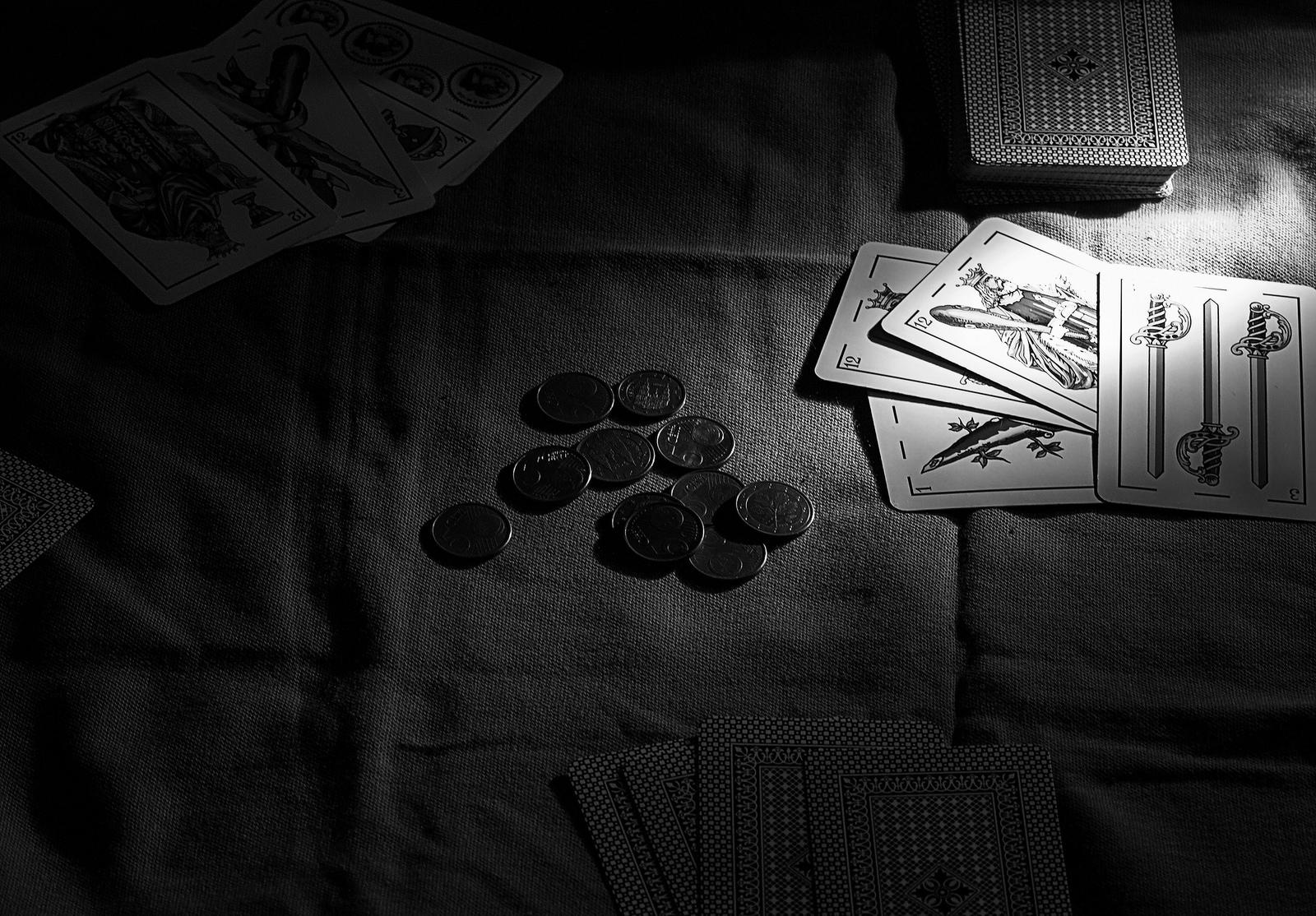 Cartas de una baraja junto a unas monedas.