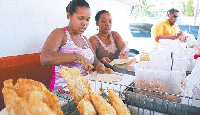 Dos chicas en un puesto de venta de empanadas.