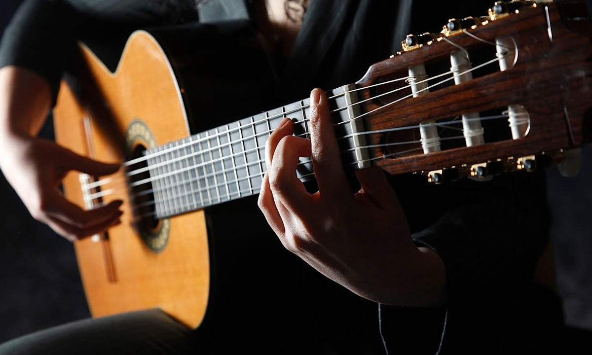 Hombre interpretando guitarra mostrando la postura correcta